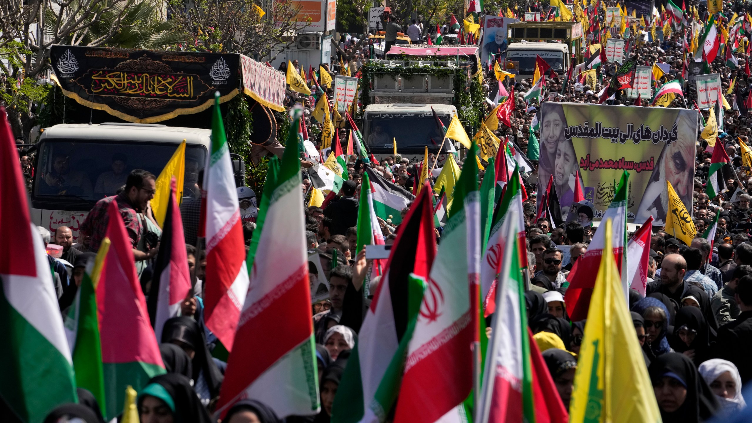 Trucks carry the coffins of Revolutionary Guard members killed in an airstrike widely attributed to Israel that destroyed Iran's Consulate in Syria on Monday, in a funeral procession in Tehran, Iran, Friday, April 5, 2024. The public funeral coincided with Iran's annual rally Quds Day, or Jerusalem Day, a traditional show of support for the Palestinians that has been held on the last Friday of the holy month of Ramadan since the 1979 Islamic Revolution. (AP Photo/Vahid Salemi)