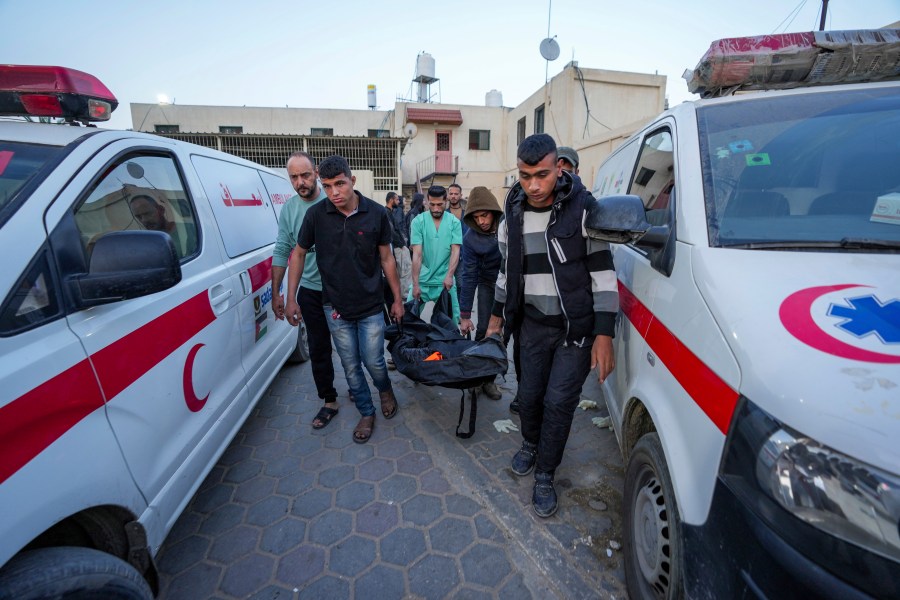 FILE - Palestinians carry the body of a World Central Kitchen worker at Al Aqsa hospital in Deir al-Balah, Gaza Strip on April 2, 2024. In Israel's drive to destroy Hamas, the rights groups and workers say Israel seems to have given itself wide leeway to determine what is a target and how many civilian deaths it allows as collateral damage. Israel says it's targeting Hamas and blames the civilian death toll on militants operating among the population. (AP Photo/Abdel Kareem Hana)