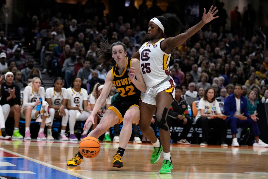 Iowa guard Caitlin Clark (22) drives past South Carolina guard Raven Johnson (25) during the first half of the Final Four college basketball championship game in the women's NCAA Tournament, Sunday, April 7, 2024, in Cleveland. (AP Photo/Carolyn Kaster)