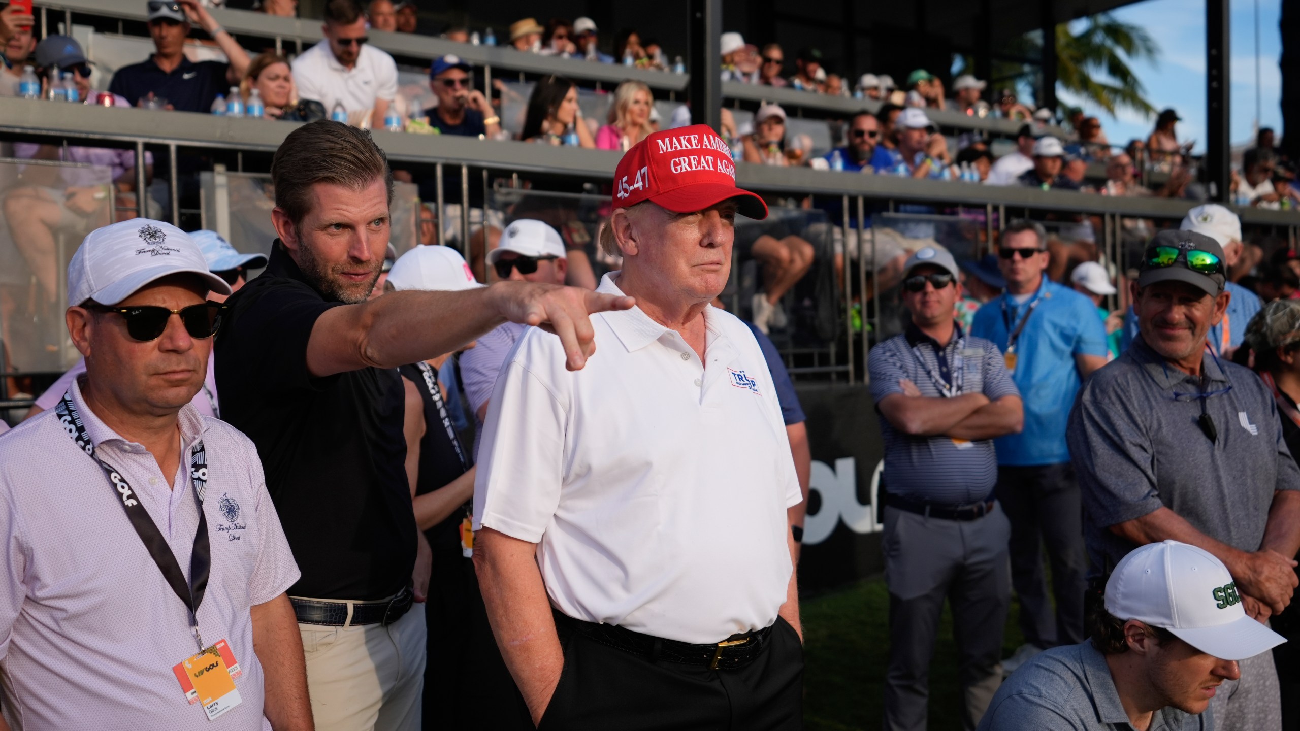 Republican presidential candidate former President Donald Trump, center, and son Eric Trump, second left, watch play on the 18th hole green during the final round of LIV Golf Miami, at Trump National Doral Golf Club, Sunday, April 7, 2024, in Doral, Fla. (AP Photo/Rebecca Blackwell)