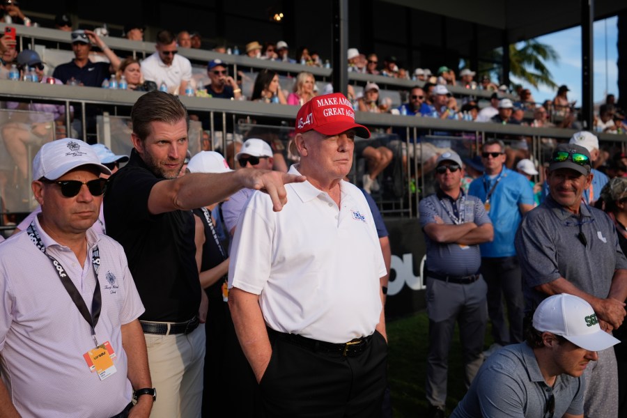 Republican presidential candidate former President Donald Trump, center, and son Eric Trump, second left, watch play on the 18th hole green during the final round of LIV Golf Miami, at Trump National Doral Golf Club, Sunday, April 7, 2024, in Doral, Fla. (AP Photo/Rebecca Blackwell)