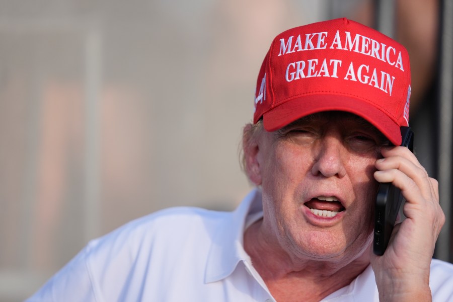 Republican presidential candidate, former President Donald Trump speaks on the phone as he watches play in the final round of LIV Golf Miami, at Trump National Doral Golf Club, Sunday, April 7, 2024, in Doral, Fla. (AP Photo/Rebecca Blackwell)