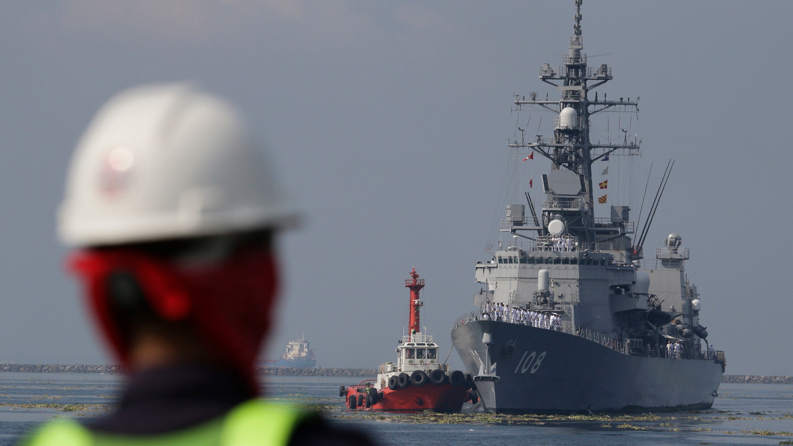 FILE - A Filipino port worker looks as the Japanese Ship Akebono (DD-108), a Murasame-class destroyer of the Japan Maritime Self-Defense Force, prepares to dock for a goodwill visit at Manila's south harbor, Philippines on Sept. 27, 2018. The United States, Japan, Australia and the Philippines will hold their first joint naval exercises, including anti-submarine warfare training, in a show of force Sunday, April 7, 2024 in the South China Sea where Beijing’s aggressive actions to assert its territorial claims have caused alarm. (AP Photo/Aaron Favila, File)