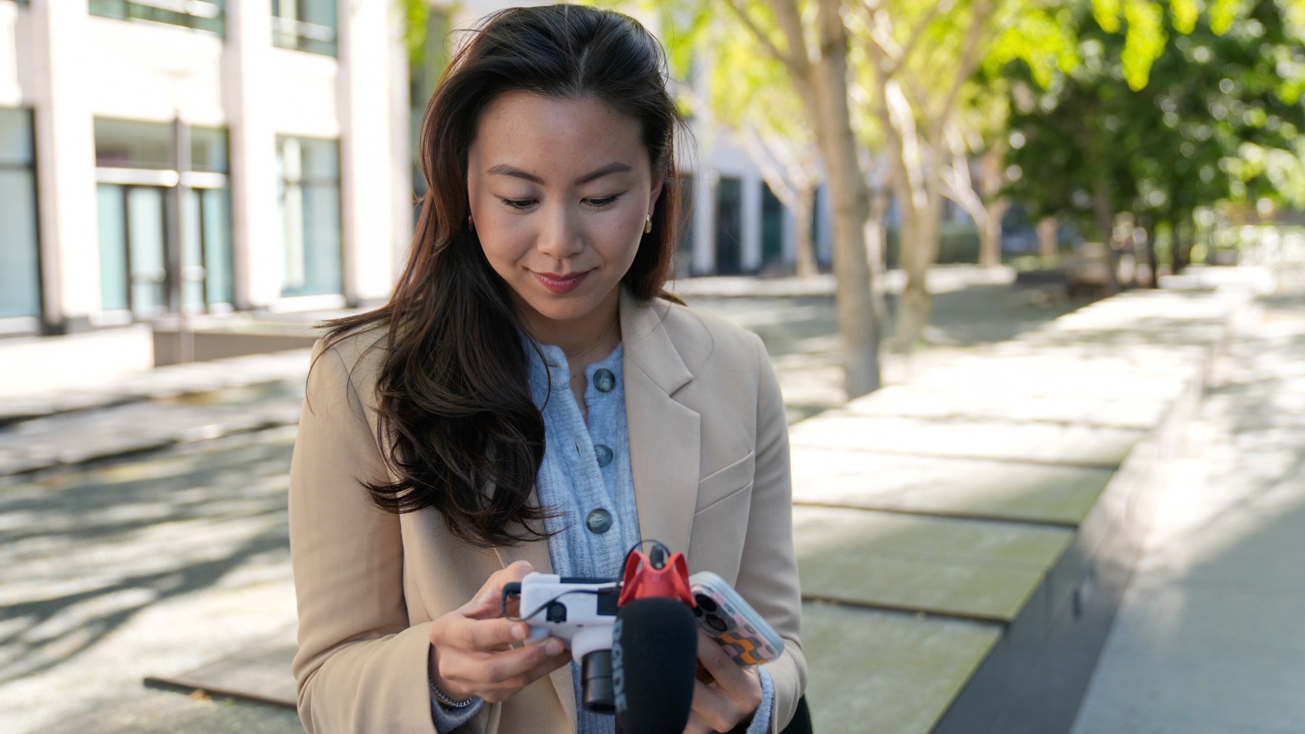 Content creator Cynthia Huang Wang edits work near the Embarcadero in San Francisco, Monday, April 8, 2024. Despite a strong job market, there are still thousands of people who have found themselves out of work across industries stretching from tech to retail to media. But rather than trying to find another job in their old role, some workers are turning to online content creation. (AP Photo/Eric Risberg)