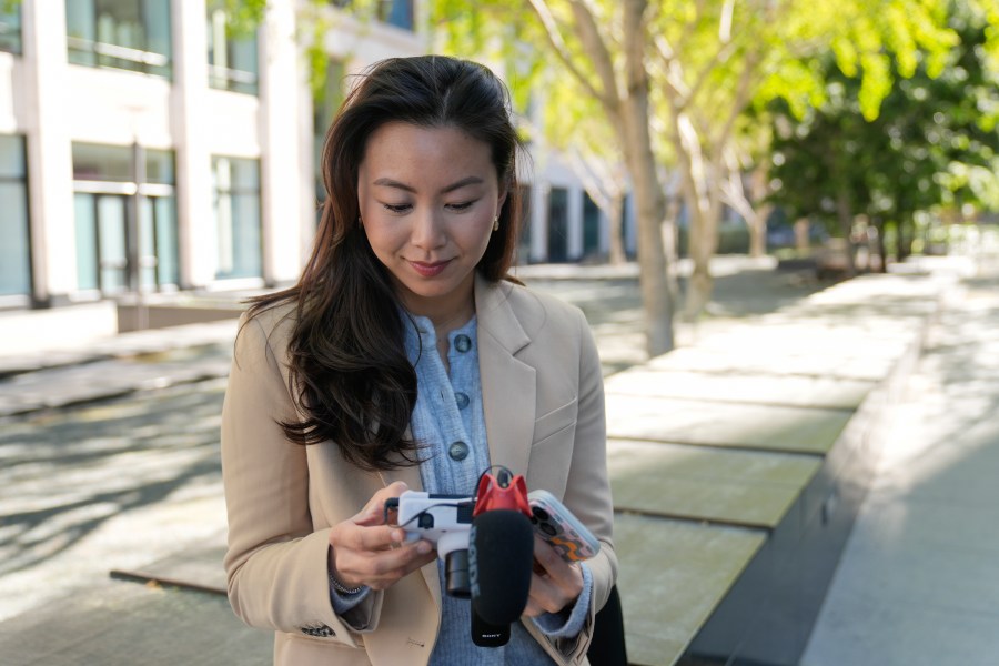 Content creator Cynthia Huang Wang edits work near the Embarcadero in San Francisco, Monday, April 8, 2024. Despite a strong job market, there are still thousands of people who have found themselves out of work across industries stretching from tech to retail to media. But rather than trying to find another job in their old role, some workers are turning to online content creation. (AP Photo/Eric Risberg)