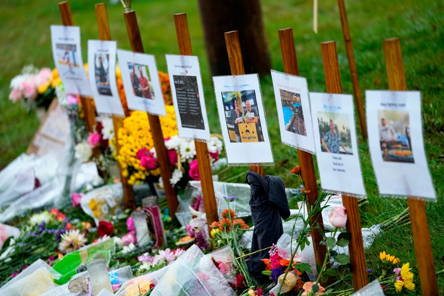 FILE - Rain soaked memorials for those who died in a mass shooting sit along the roadside by Schemengees Bar & Grille, Monday, Oct. 30, 2023, in Lewiston, Maine. Testimony stretched into a second day, Tuesday, April 9, 2024, as a legislative committee heard testimony on the red flag proposal that aims to let family members or others petition a judge to initiate the process of temporarily removing someone’s guns during a psychiatric crisis. (AP Photo/Matt York, File)