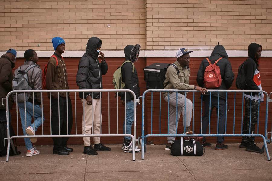 FILE - Migrants queue in the cold as they look for a shelter outside a Migrant Assistance Center at St. Brigid Elementary School on Tuesday, Dec. 5, 2023, in New York. Mayor Eric Adam's office on Tuesday, April 9, 2024, said New York City will end its relationship with a medical services company tasked with housing and caring for an influx of international migrants, following scrutiny over the company's lucrative deal with the city and the quality of its humanitarian services. (AP Photo/Andres Kudacki. File)