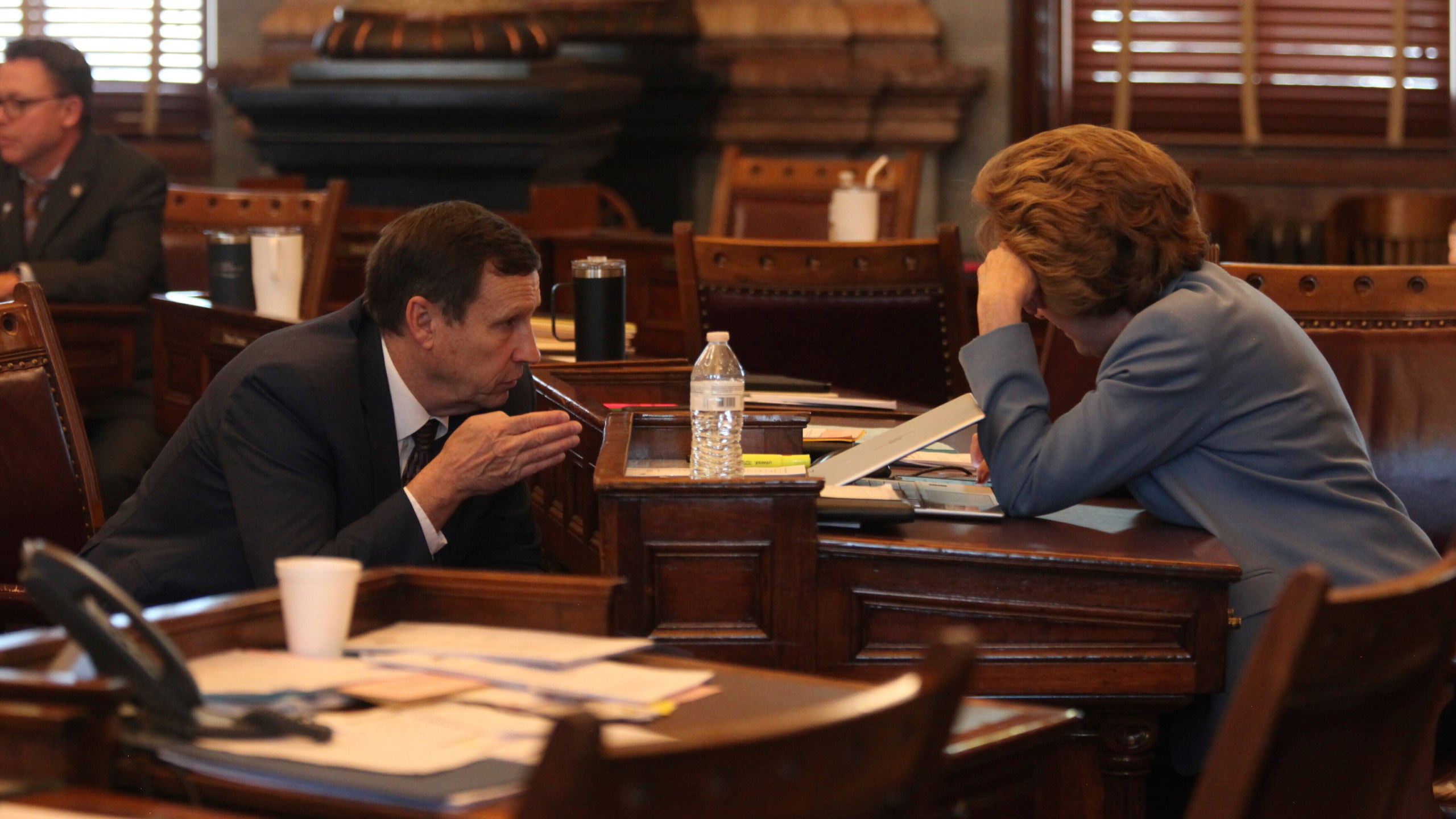 Kansas state Sen. Dennis Pyle, left, R-Hiawatha, confers with Sen. Brenda Dietrich, R-Topeka, during the Senate session, Friday, April 5, 2024, at the Statehouse in Topeka, Kan. Pyle supports a bill to make it a crime to coerce someone into having an abortion, while Dietrich passed the last time senators considered it. (AP Photo/John Hanna)