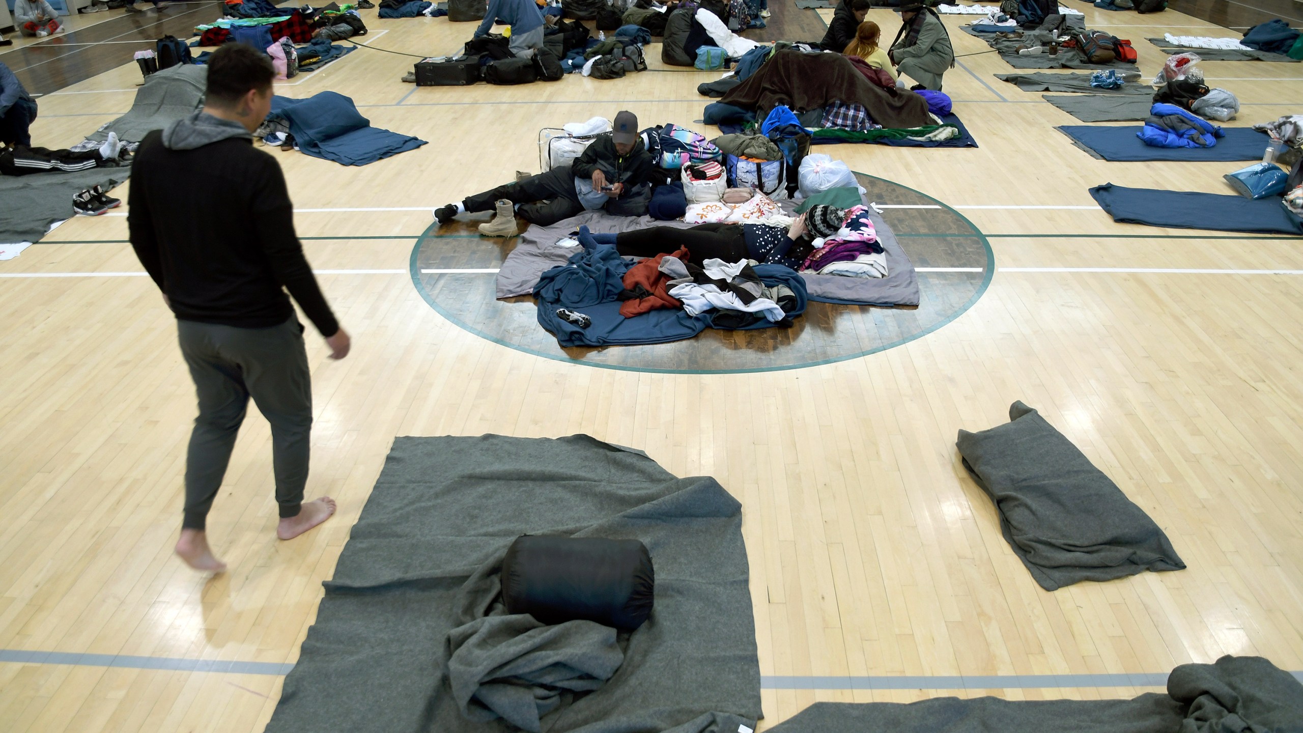 FILE - Migrants rest at a makeshift shelter, Jan. 6, 2023, in Denver. Denver Mayor Mike Johnston announced a major shift Wednesday, April 10, 2024, in the city's response to the migrant crisis, extending support to six months but with only 1,000 spaces. The mayor's pivot follows failed attempts to get federal aid and deep cuts to the city's budget as Denver served nearly 41,000 migrants since the end of 2022. (AP Photo/Thomas Peipert, File)