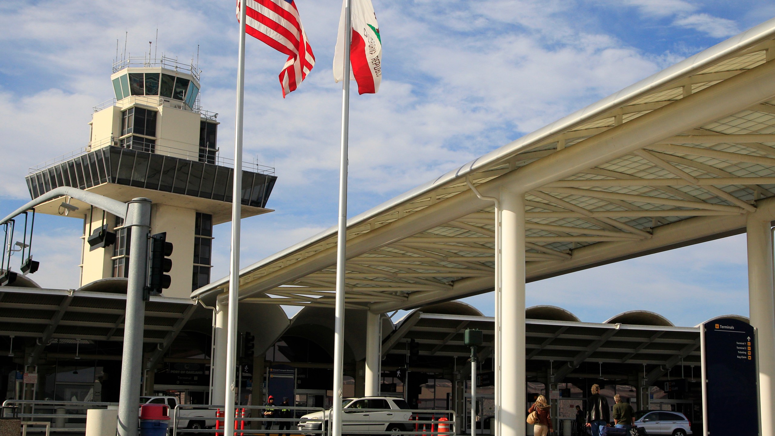 FILE - Travelers prepare to enter Oakland International airport Tuesday, Nov. 26, 2013, in Oakland, Calif. Oakland's airport is considering a name-change to include “San Francisco” to attract more passengers but San Francisco officials are slamming the move, saying it will confuse travelers since there is already a San Francisco International Airport. The Board of Commissioners for the Port of Oakland will take up the question at its meeting on Thursday, April 11, 2024. (AP Photo/Ben Margot, File)