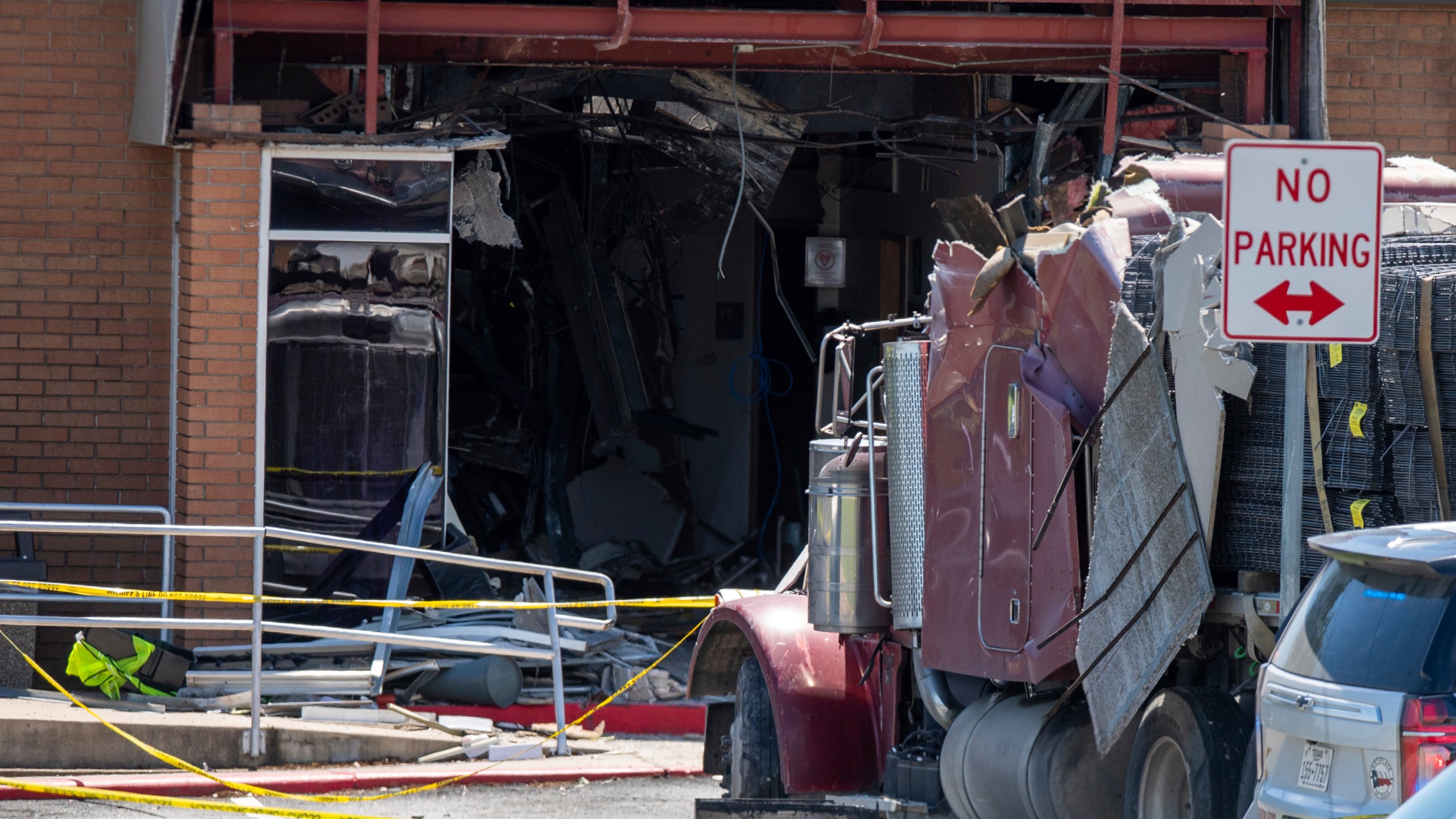 A stolen 18-wheeler crashed into a Texas Department of Public Safety office on US-290 in Brenham, Texas on Friday, April 12, 2024. The driver of a stolen semitrailer intentionally rammed it into the Texas public safety office in a rural town west of Houston on Friday, injuring multiple people, according to a state lawmaker. (Meredith Seaver/College Station Eagle via AP)