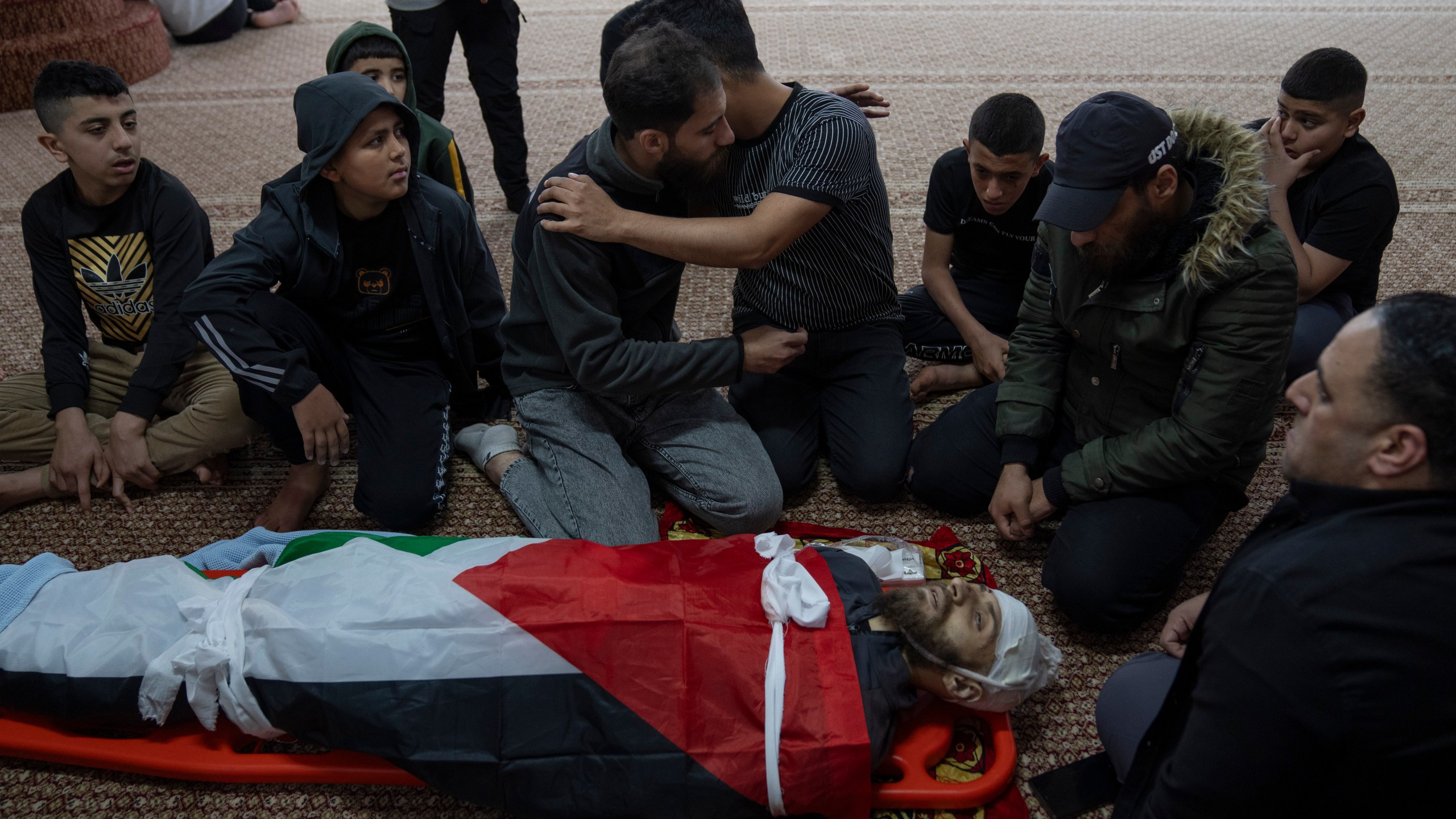 Mourners take the last look at the body of Palestinian Mohammad Shahmawi, 22, at a mosque in the West Bank refugee camp of al-Faraa, Friday, April 12, 2024. Two Palestinians were killed early Friday in confrontations with Israeli forces in the Israeli-occupied West Bank, Palestinian medics and the Israeli military said. The Islamic militant group Hamas said one of those killed was a local commander. (AP Photo/Nasser Nasser)