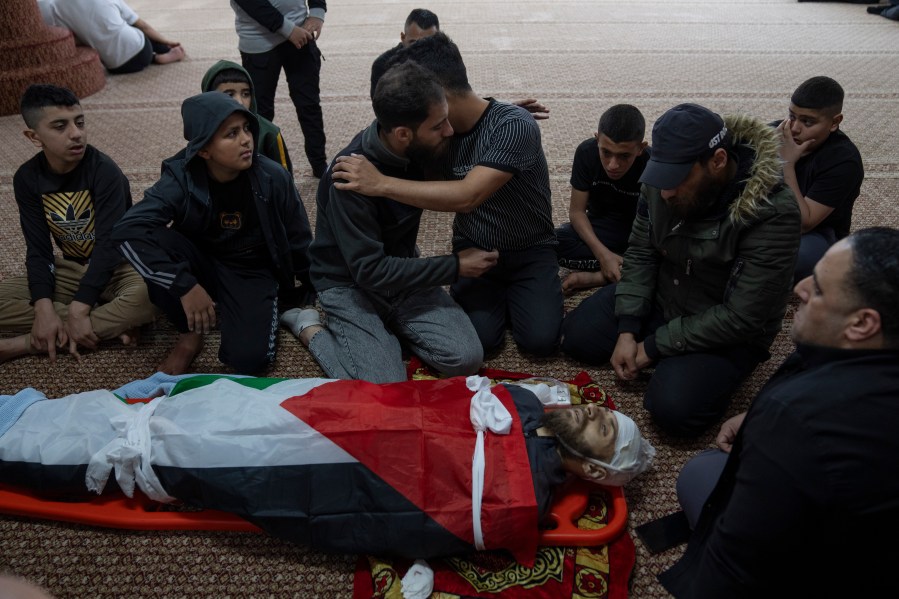 Mourners take the last look at the body of Palestinian Mohammad Shahmawi, 22, at a mosque in the West Bank refugee camp of al-Faraa, Friday, April 12, 2024. Two Palestinians were killed early Friday in confrontations with Israeli forces in the Israeli-occupied West Bank, Palestinian medics and the Israeli military said. The Islamic militant group Hamas said one of those killed was a local commander. (AP Photo/Nasser Nasser)