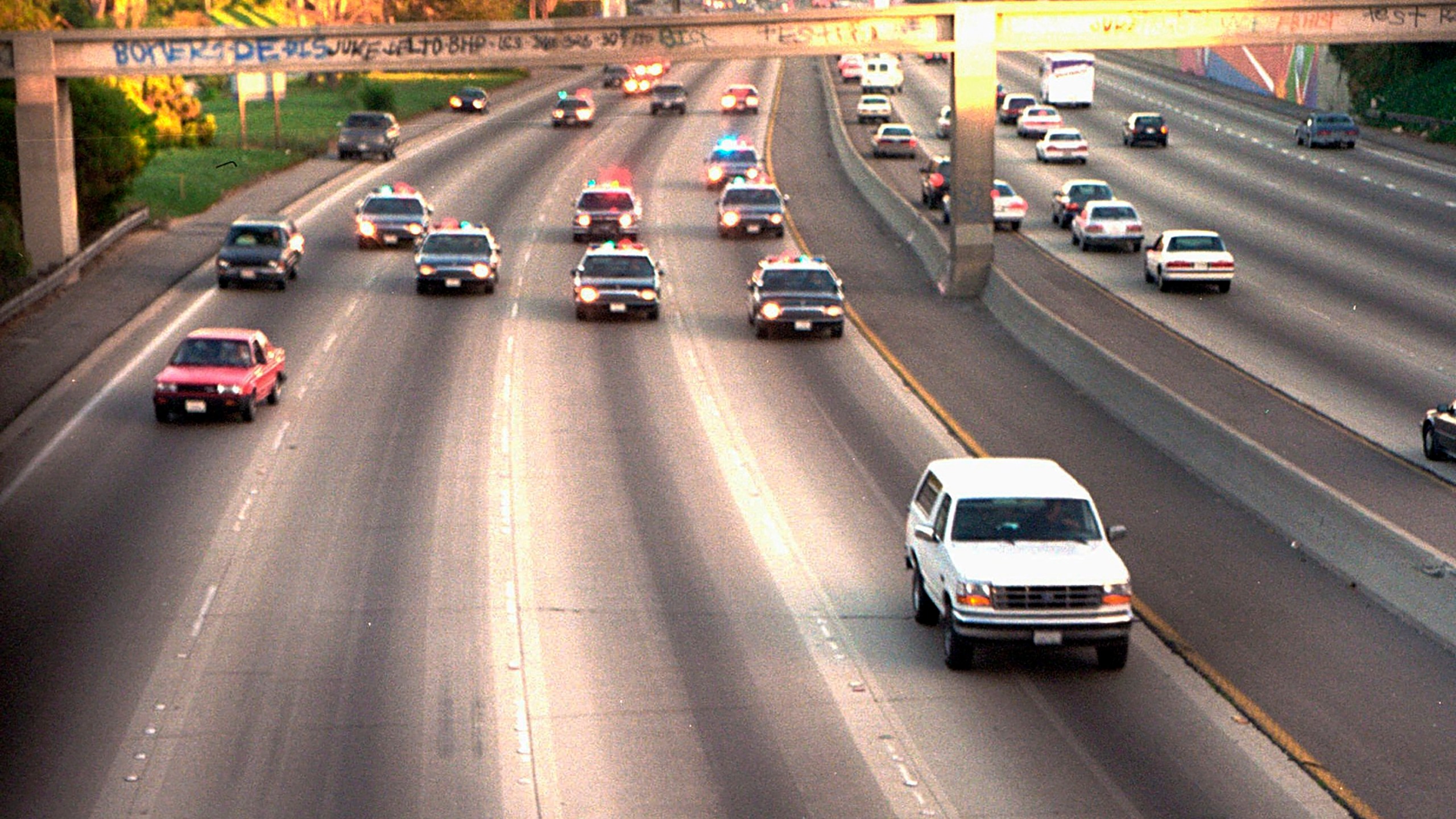 FILE - In this June 17, 1994, file photo, a white Ford Bronco, driven by Al Cowlings carrying O.J. Simpson, is trailed by Los Angeles police cars as it travels on a freeway in Los Angeles. Simpson, the decorated football superstar and Hollywood actor who was acquitted of charges he killed his former wife and her friend but later found liable in a separate civil trial, has died. He was 76. (AP Photo/Joseph Villarin, File)