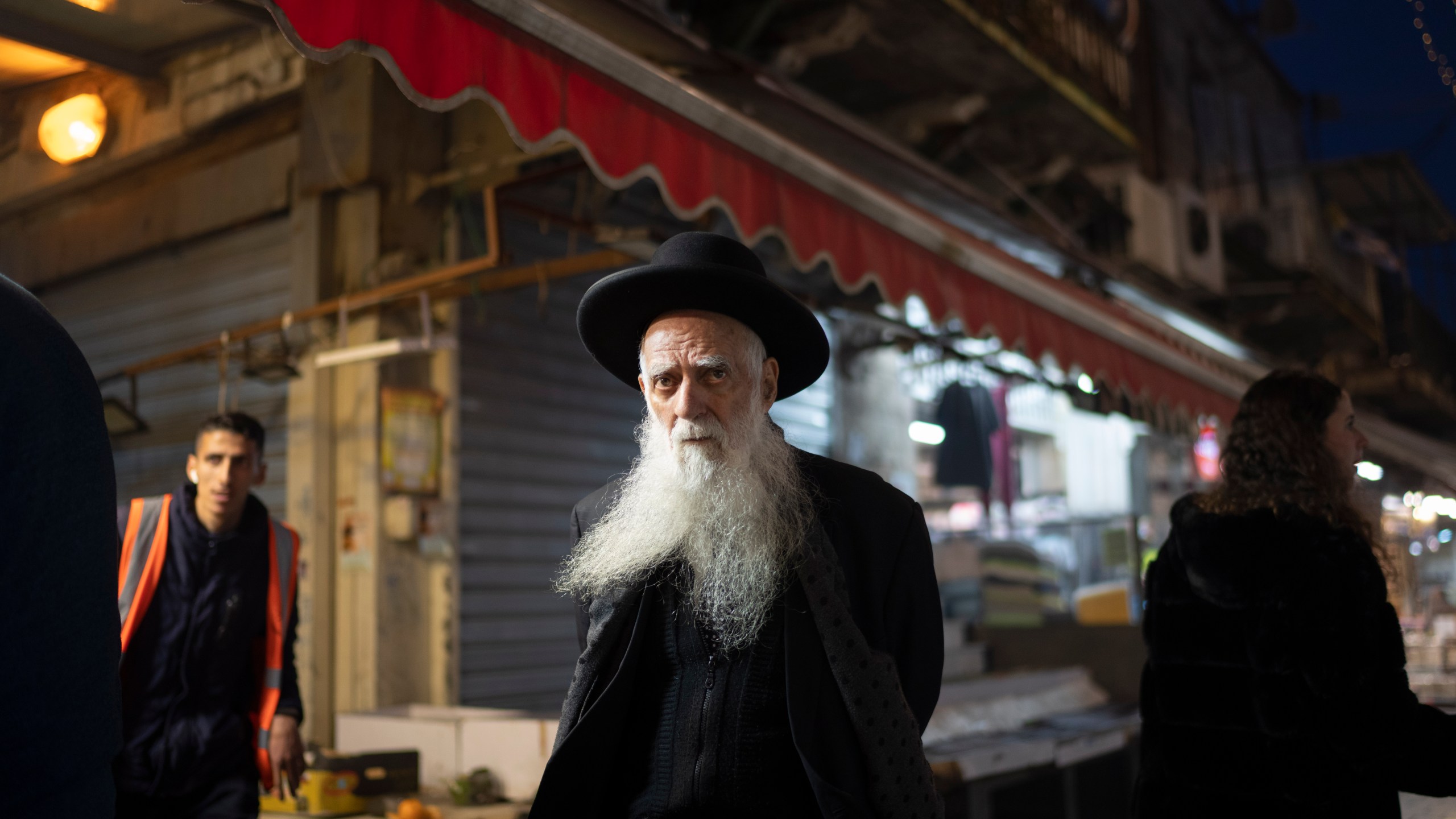 An elderly ultra-Orthodox Jewish man looks on as he walks in the Mahane Yehuda market in Jerusalem, Sunday, April 14, 2024. Israel on Sunday hailed its air defenses in the face of an unprecedented attack by Iran, saying the systems thwarted 99% of the more than 300 drones and missiles launched toward its territory. (AP Photo/Leo Correa)