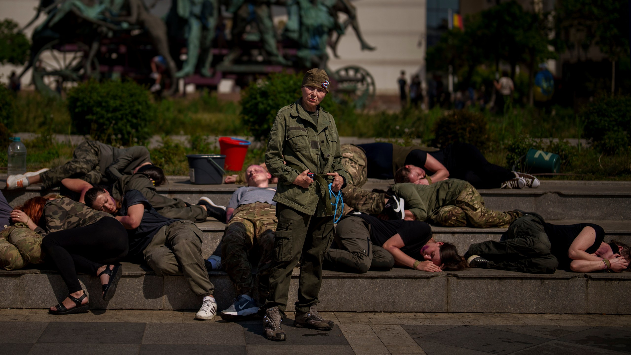 Ukrainian refugees, one impersonating a Russian soldier, other playing roles of Ukrainian war prisoners, perform during an event in Bucharest, Romania, Saturday, April 13, 2024. Members of the Ukrainian refugee community staged an event dubbed "Voices of Captives" to raise awareness to the plight of Ukrainian servicemen and civilians still in Russian custody. (AP Photo/Vadim Ghirda)