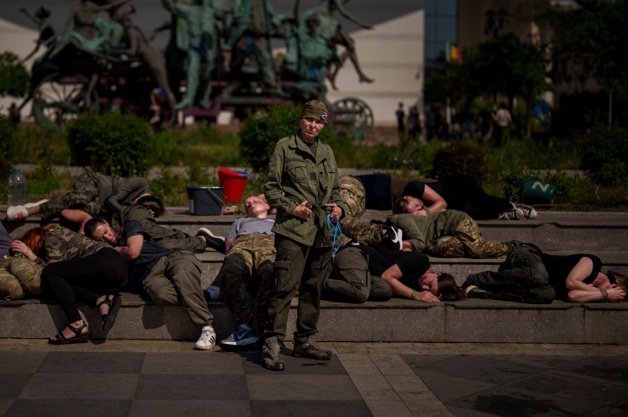 Ukrainian refugees, one impersonating a Russian soldier, other playing roles of Ukrainian war prisoners, perform during an event in Bucharest, Romania, Saturday, April 13, 2024. Members of the Ukrainian refugee community staged an event dubbed "Voices of Captives" to raise awareness to the plight of Ukrainian servicemen and civilians still in Russian custody. (AP Photo/Vadim Ghirda)