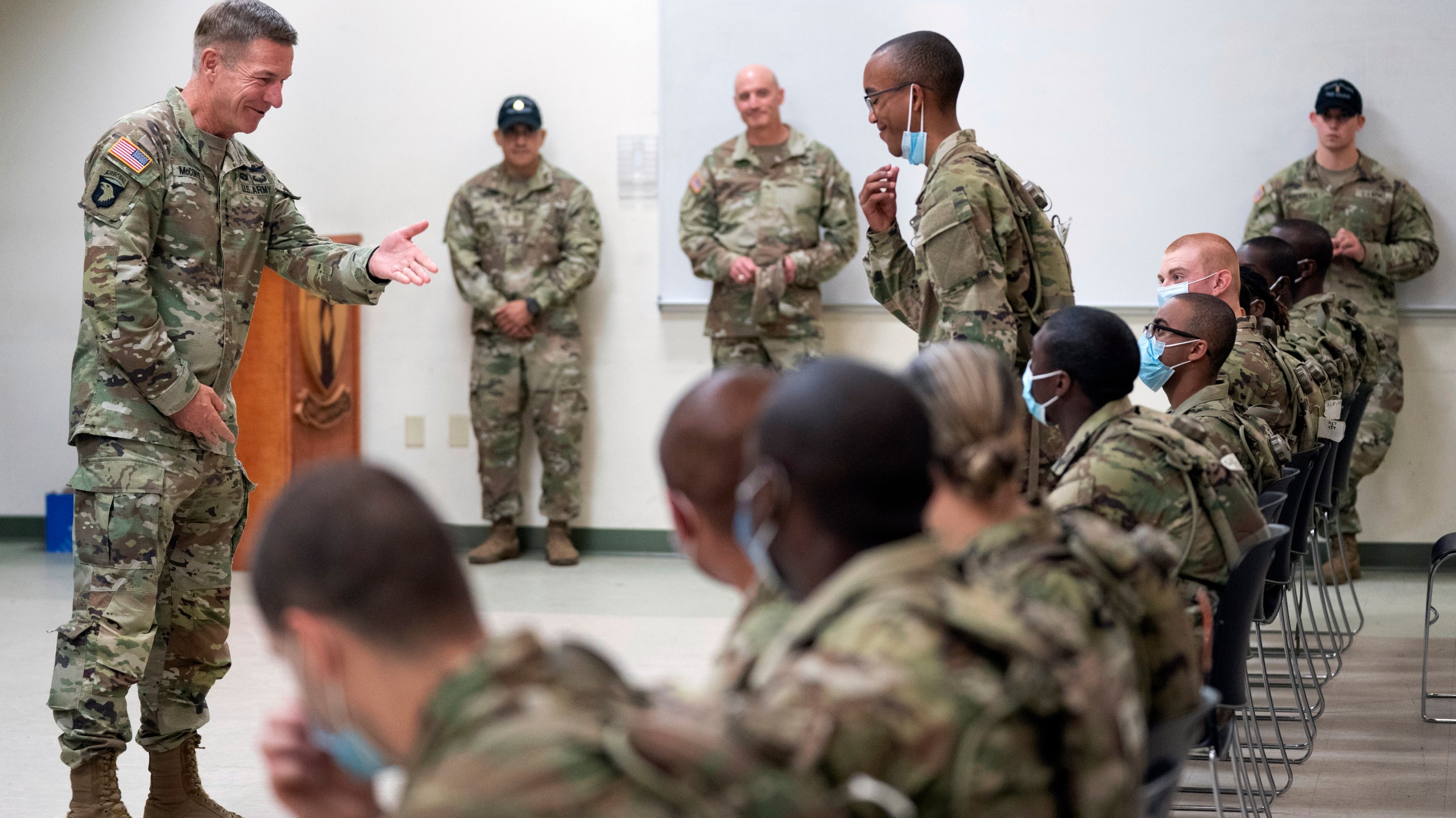 FILE - Chief of Staff of the Army Gen. James McConville left, gestures to a student in the new Army prep course at Fort Jackson, S.C., Friday, Aug. 26, 2022, as McConville visited to see the new course, an effort to better prepare recruits for the demands of basic training. The Army and Air Force say they are on track to meet their recruiting goals in 2024, reversing previous shortfalls using a swath of new programs and policy changes. But the Navy, while improving, expects once again to fall short. (AP Photo/Sean Rayford, File)