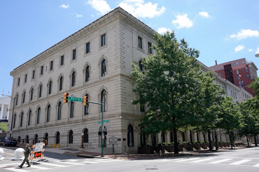 FILE - A pedestrian passes by the US 4th Circuit Court of Appeals Courthouse on Main Street in Richmond, Va., Wednesday, June 16, 2021. West Virginia's transgender sports ban violates the rights of a teen athlete under Title IX, the federal civil rights law that prohibits sex-based discrimination in schools, an appeals court ruled Tuesday, April 16, 2024. The 4th U.S. Circuit Court of Appeals ruled 2-1 that the law cannot be applied to a 13-year-old who has been taking puberty-blocking medication and publicly identified as a girl since she was in the third grade. (AP Photo/Steve Helber, File)