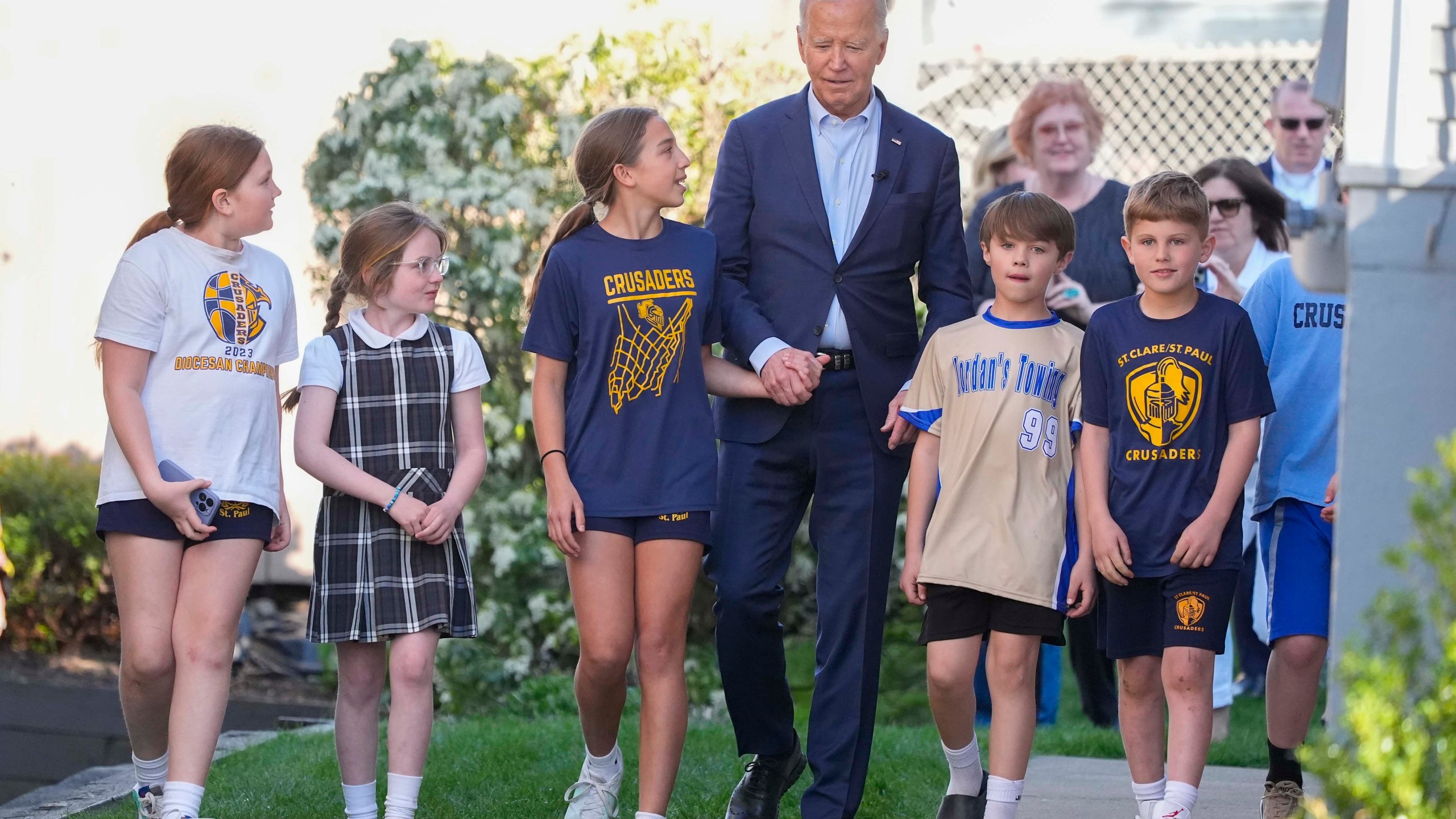 President Joe Biden walks out of his childhood home with a group of unidentified children, Tuesday, April 16, 2024, in Scranton, Pa. (AP Photo/Alex Brandon)