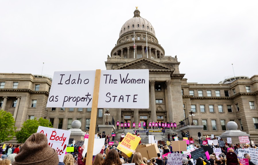 FILE - An attendee at Planned Parenthood's Bans Off Our Bodies rally for abortion rights holds a sign reading "Idaho the women as property state" outside of the Idaho Statehouse in downtown Boise, Idaho, on May 14, 2022. A new Idaho organization says it will ask voters to restore abortion access and other reproductive health care rights in the state after lawmakers let a second legislative session end without modifying strict abortion bans that have been blamed for a recent exodus of health care providers. . (Sarah A. Miller/Idaho Statesman via AP, File)