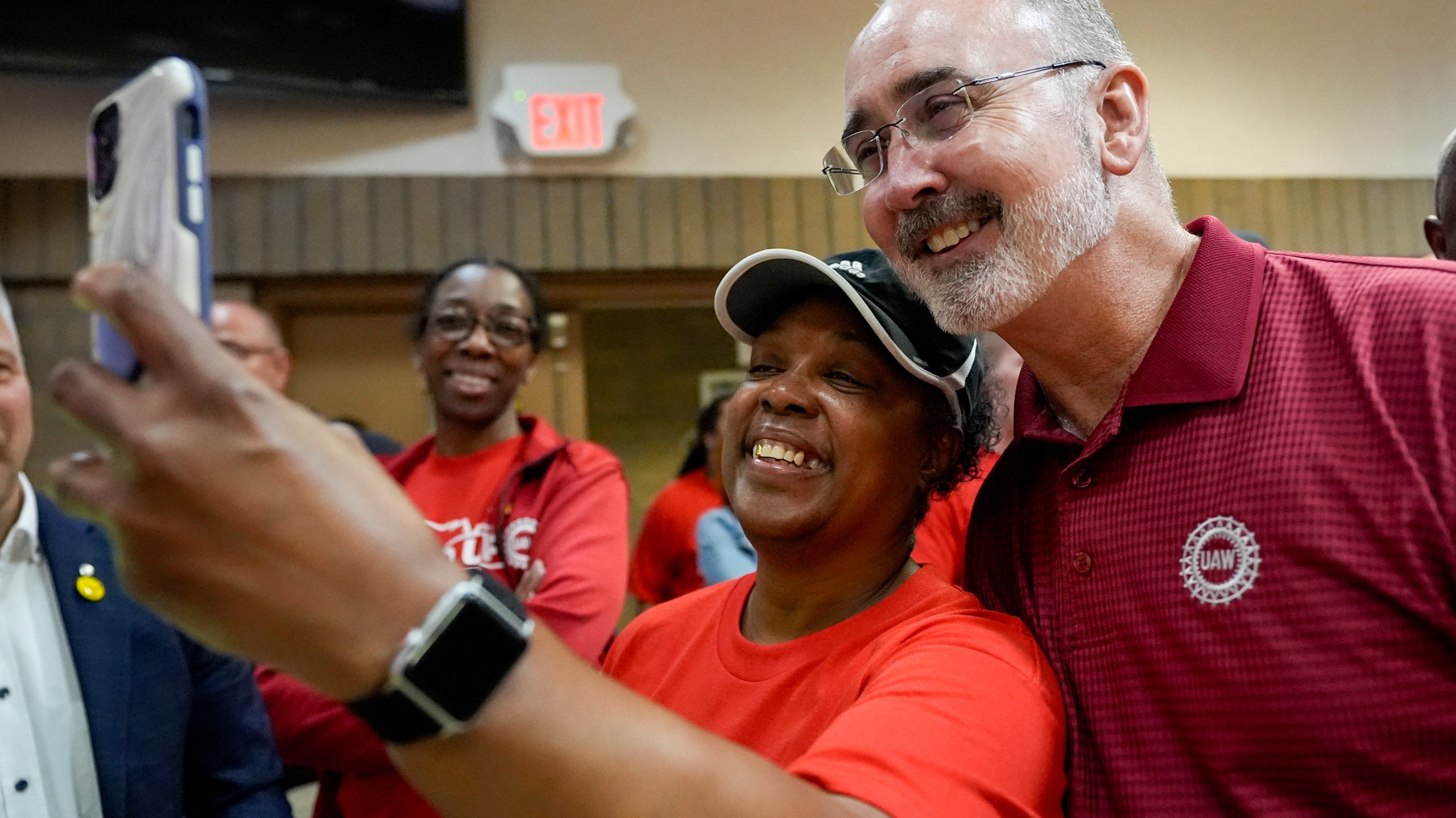 Volkswagen automobile plant employee LaShawn Hawthorne, center left, takes picture with UAW president Shawn Fain after workers voted to join the union Friday, April 19, 2024, in Chattanooga, Tenn. (AP Photo/George Walker IV)