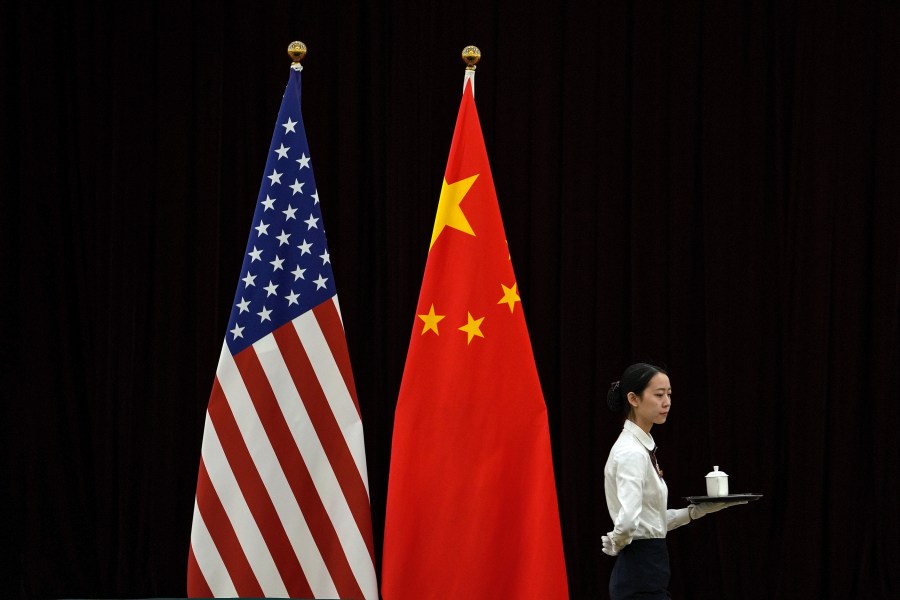 FILE - A hostess walks by the national flags of the United States and China ahead of the bilateral meeting between U.S. Treasury Secretary Janet Yellen and Chinese Vice Premier He Lifeng, at the Guangdong Zhudao Guest House in southern China's Guangdong province, April 6, 2024. Simmering tensions between Beijing and Washington remain the top worry for U.S. companies operating in China, according to a report by the American Chamber of Commerce in China released Tuesday, April 23, 2024. (AP Photo/Andy Wong, Pool, File)