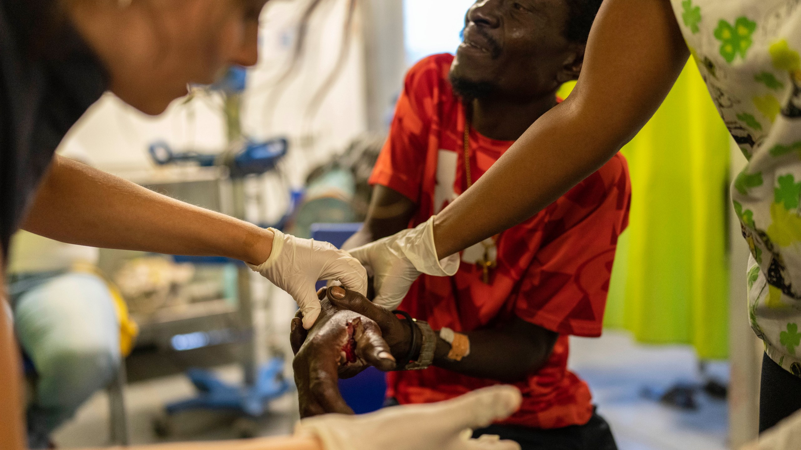 FILE - Marc Baptiste is treated for a bullet wound at a Doctors Without Borders emergency room in the Cite Soleil neighborhood of Port-au-Prince, Haiti, Friday, April 19, 2024. Baptiste said police in an armored vehicle shot him the previous day as he was collecting wood to sell as kindling in an area controlled by gangs. Haiti's health system has long been fragile, but it's now nearing total collapse after gangs launched coordinated attacks on Feb. 29, targeting critical state infrastructure in the capital and beyond. (AP Photo/Ramon Espinosa, File)