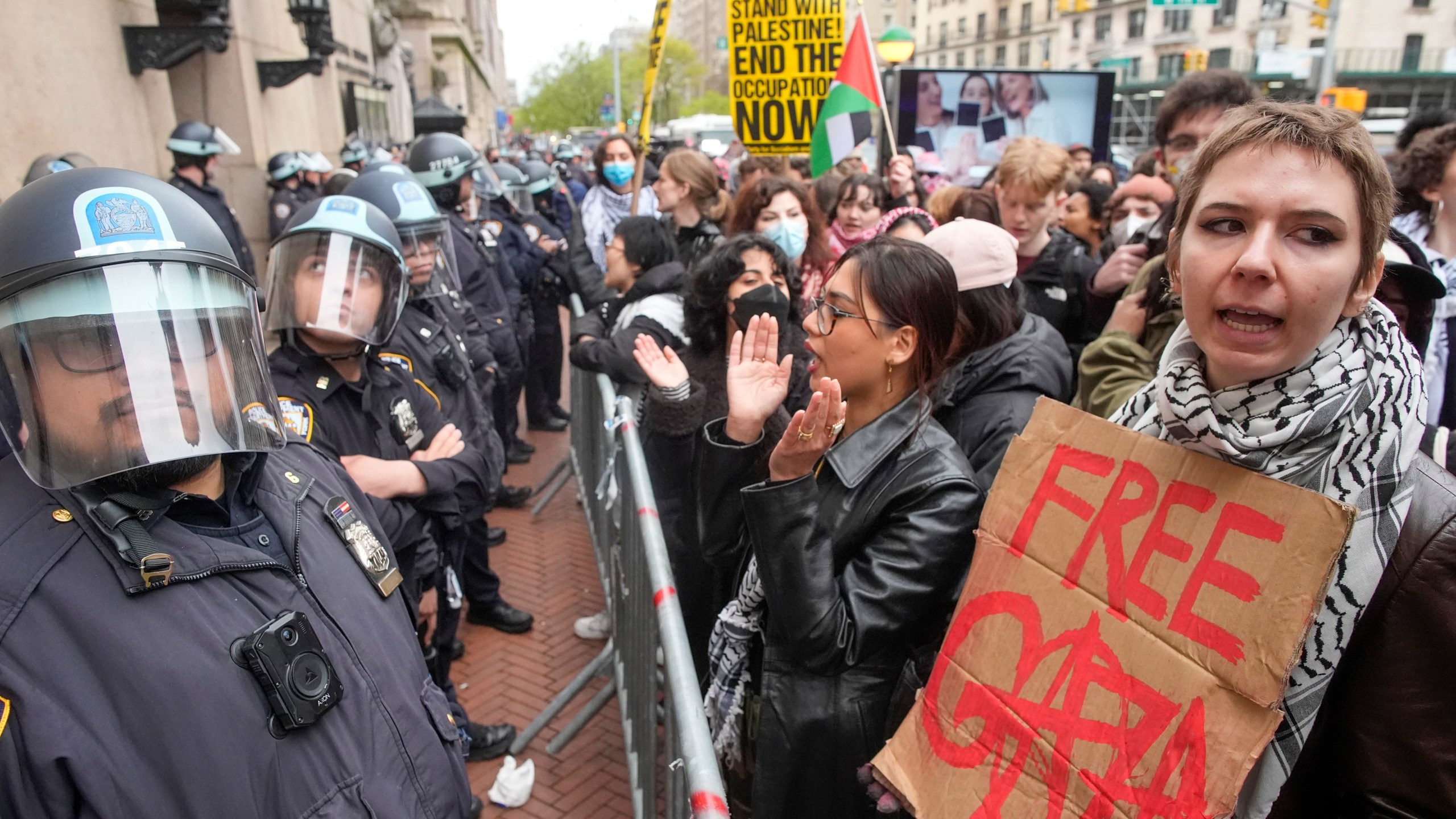 FILE - Police in Riot gear stand guard as demonstrators chant slogans outside the Columbia University campus, Thursday, April 18, 2024, in New York. U.S. colleges and universities are preparing for end-of-year commencement ceremonies with a unique challenge: providing safety for graduates while honoring the free speech rights of students involved in protests over the Israel-Hamas war. (AP Photo/Mary Altaffer, File)