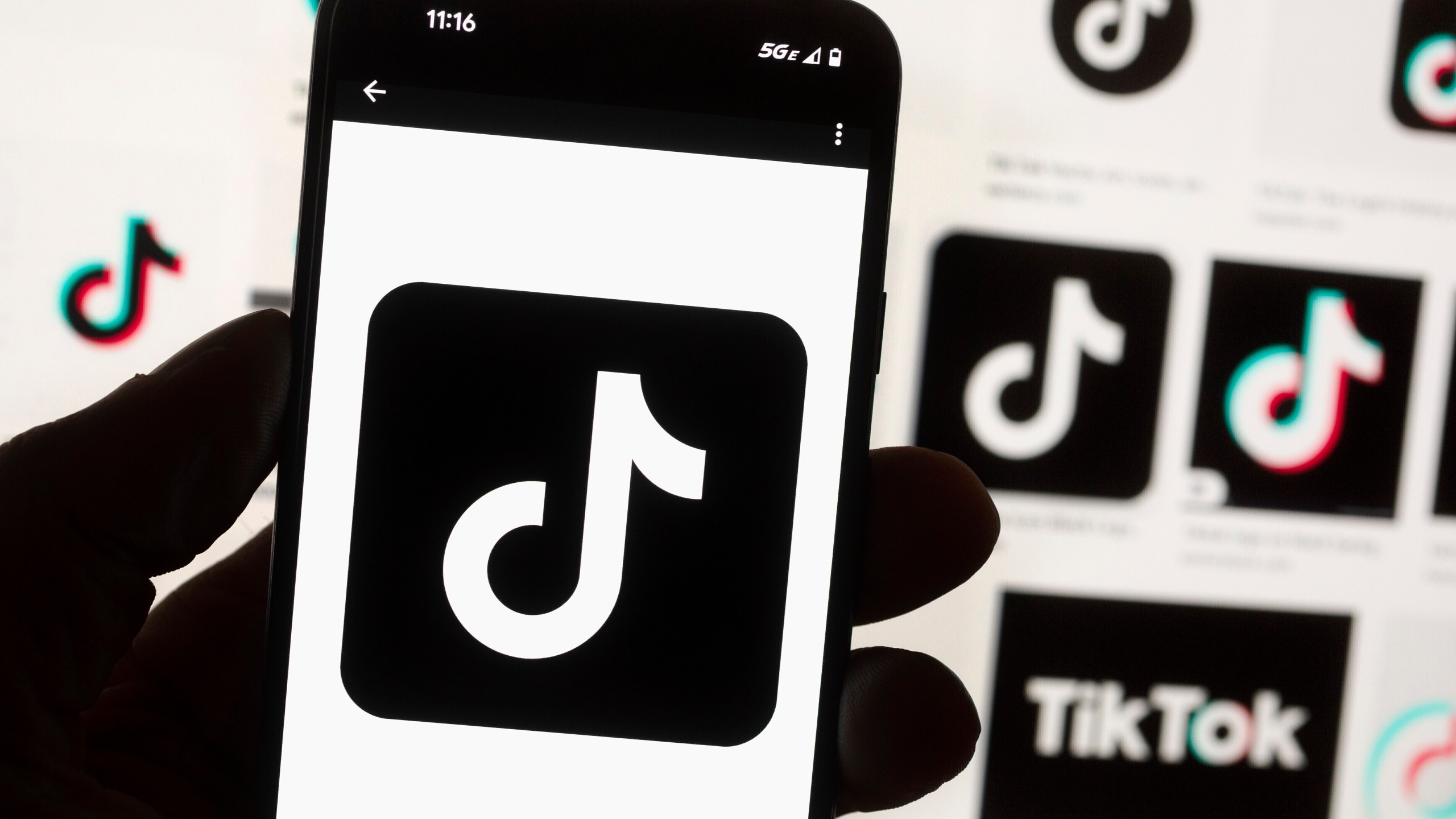 FILE - The TikTok logo is displayed on a mobile phone in front of a computer screen, Oct. 14, 2022, in Boston. TikTok is gearing up for a legal fight against a U.S. law that would force the social media platform to break ties with its China-based parent company or face a ban. A battle in the courts will almost certainly be backed by Chinese authorities as the bitter U.S.-China rivalry threatens the future of a wildly popular way for young Americans to connect online. (AP Photo/Michael Dwyer, File)