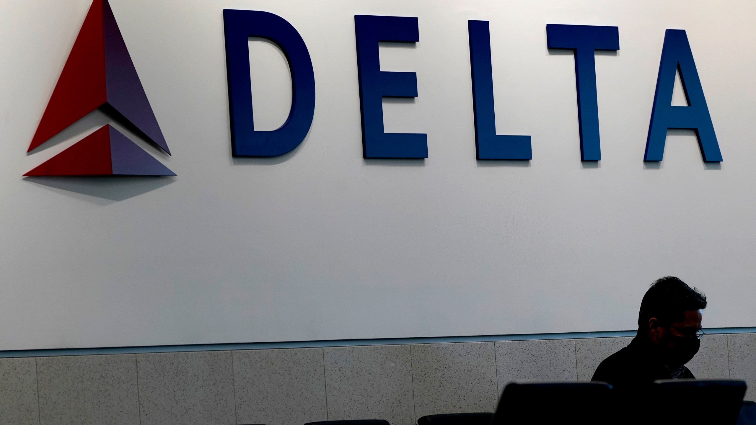 A man waits for a Delta Air Lines flight at Hartsfield-Jackson International Airport in Atlanta, Jan. 7, 2022.