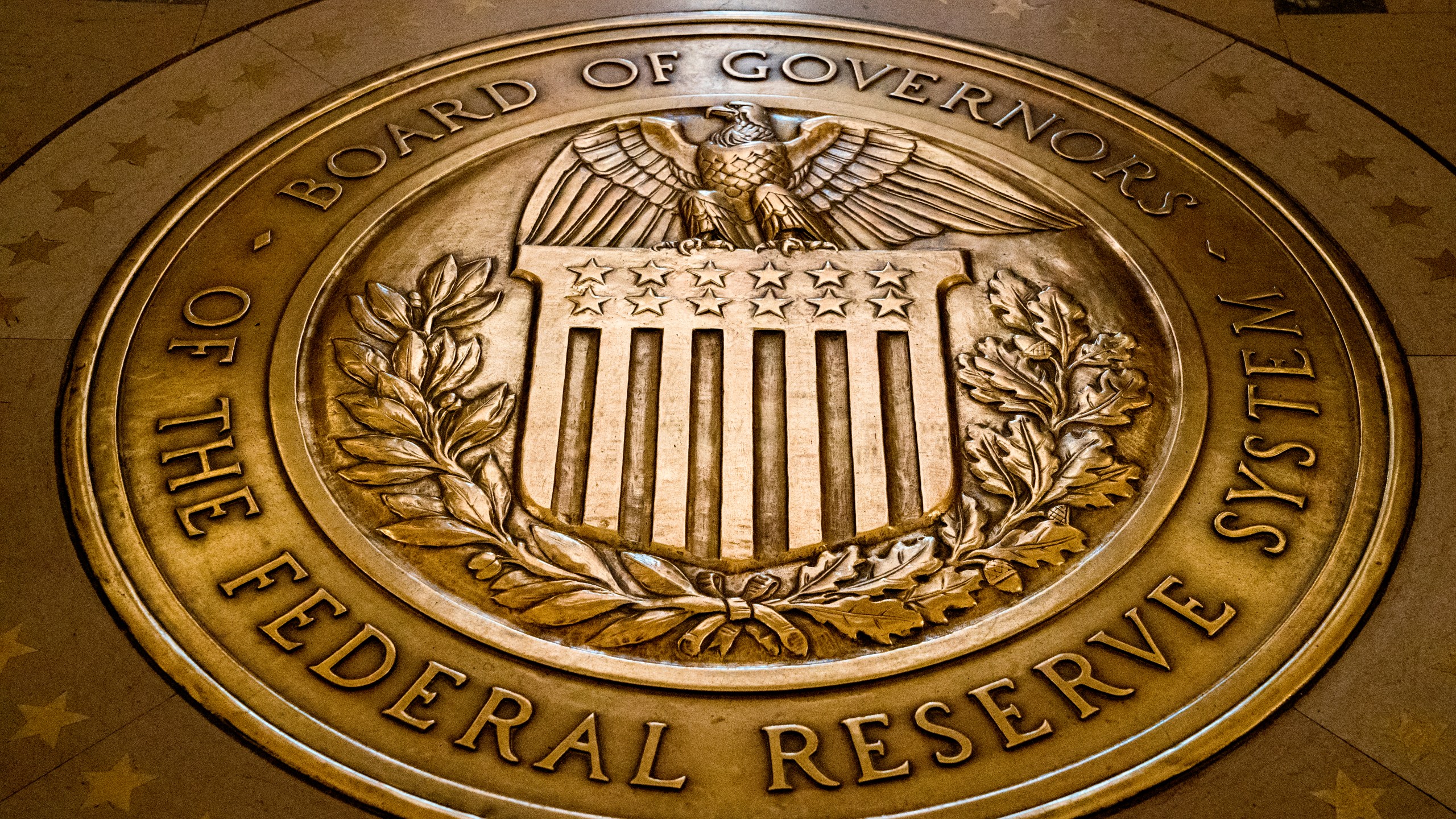 FILE- In this Feb. 5, 2018, file photo, the seal of the Board of Governors of the United States Federal Reserve System is displayed in the ground at the Marriner S. Eccles Federal Reserve Board Building in Washington. (AP Photo/Andrew Harnik, File)