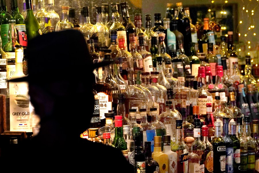 FILE - Bottles of alcohol sit on shelves at a bar in Houston on June 23, 2020. Moderate drinking was once thought to have benefits for the heart, but better research methods starting in the 2010s have thrown cold water on that. (AP Photo/David J. Phillip, File)