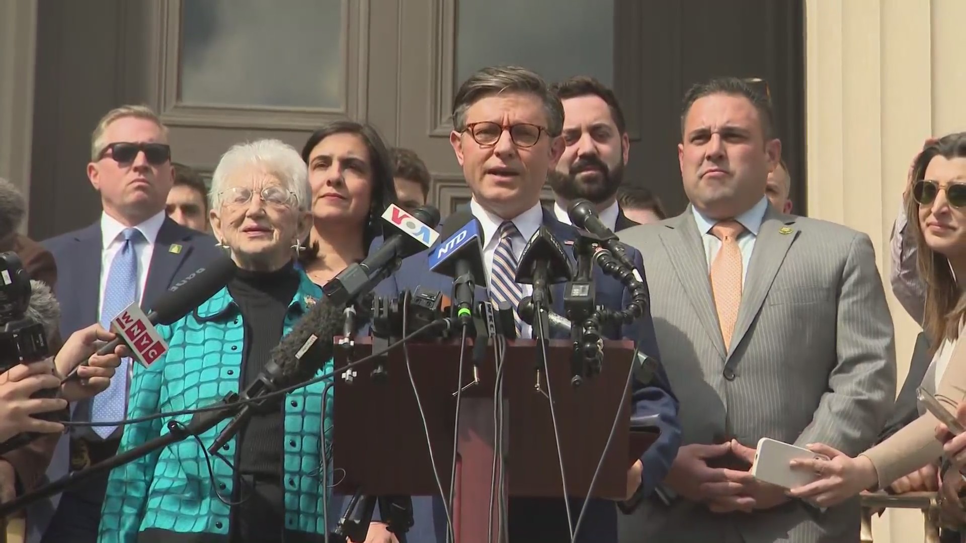 Speaker Mike Johnson at a podium with other lawmakers.