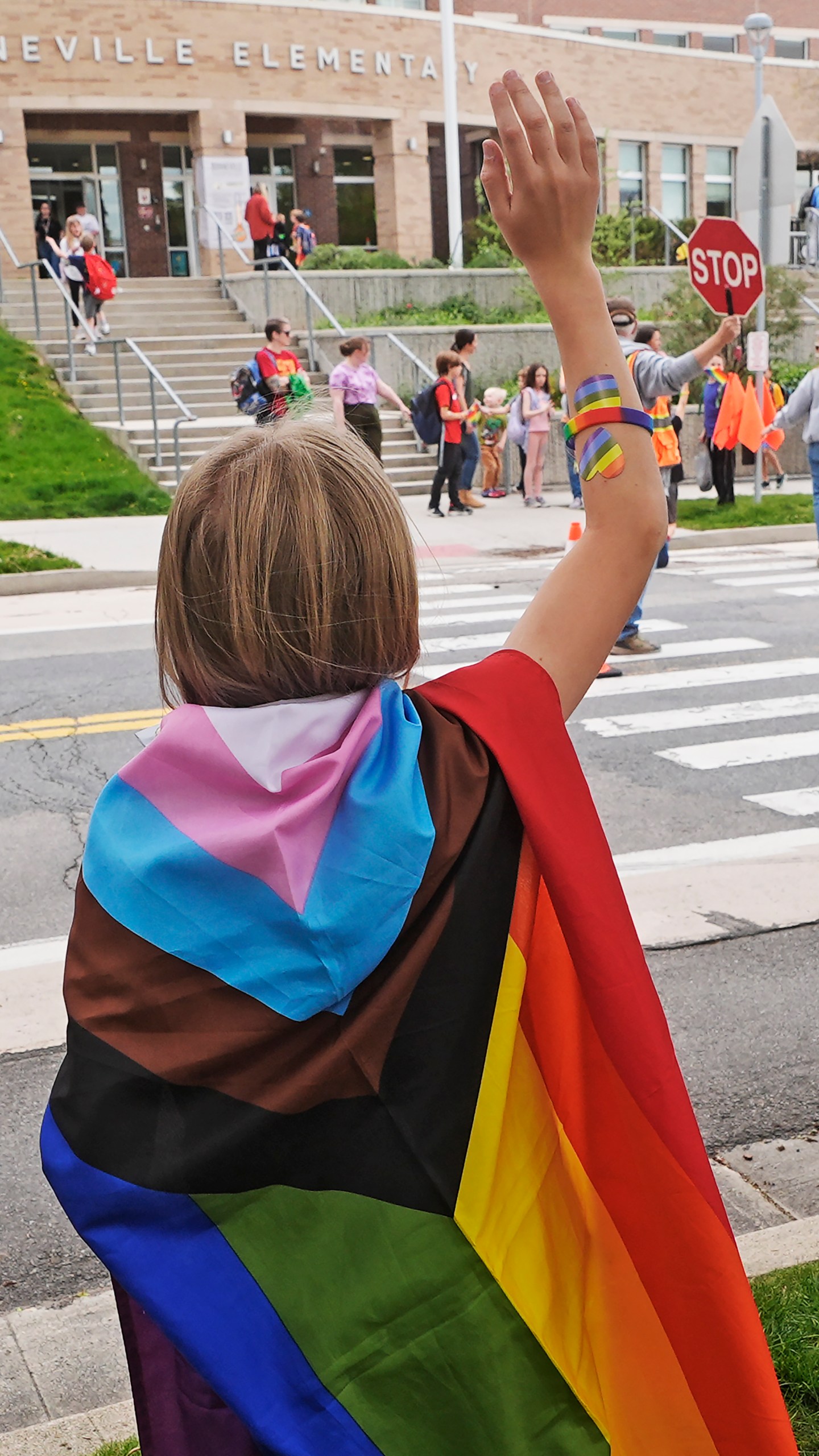 Bonneville Elementary School 5th grader Graham Beeton, waves to fellow students during a block party supporting trans and non binary students and staff Monday, April 29, 2024, in Salt Lake City. Utah will become the latest state to implement restrictions for transgender people using school bathrooms and locker rooms in public schools and government-owned buildings when key components of a law passed by the Republican controlled Legislature take effect May 1. (AP Photo/Rick Bowmer)