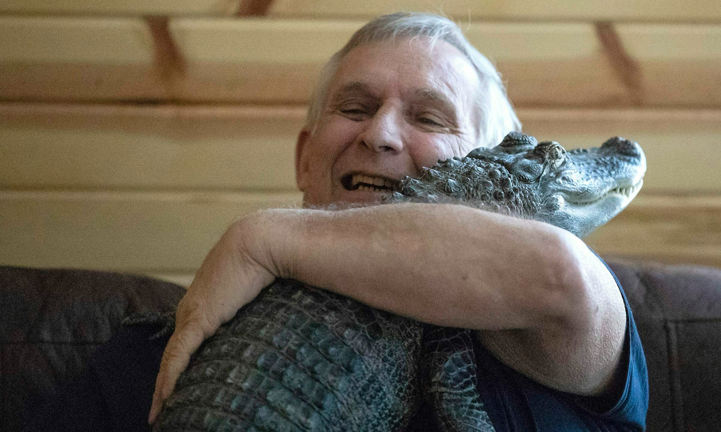 FILE - Joie Henney hugs his emotional support alligator named Wally, Jan. 22, 2019, inside their home in York Haven, Pa. Henney credits Wally for helping relieve his depression for nearly a decade, says he's searching for the reptile after it went missing during a vacation to the coast of Georgia. (Heather Khalifa/The Philadelphia Inquirer via AP, File)