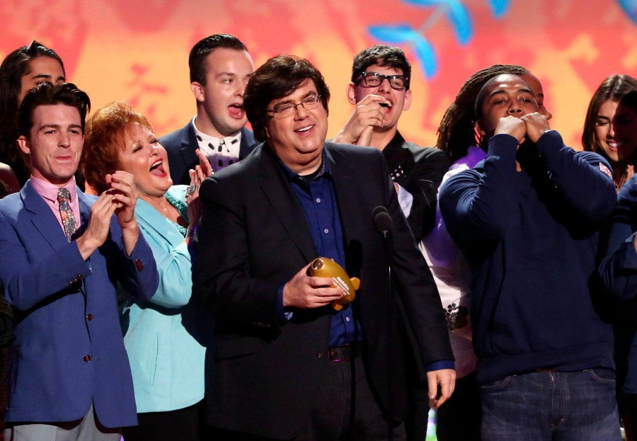 FILE - Dan Schneider, center, accepts an award in Los Angeles. Schneider sued the makers of “Quiet on Set: The Dark Side of Kids TV” on Wednesday, May 1, 2024, alleging the makers of the documentary series wrongly implied that he sexually abused the child actors he worked with. (Photo by Matt Sayles/Invision/AP, File)