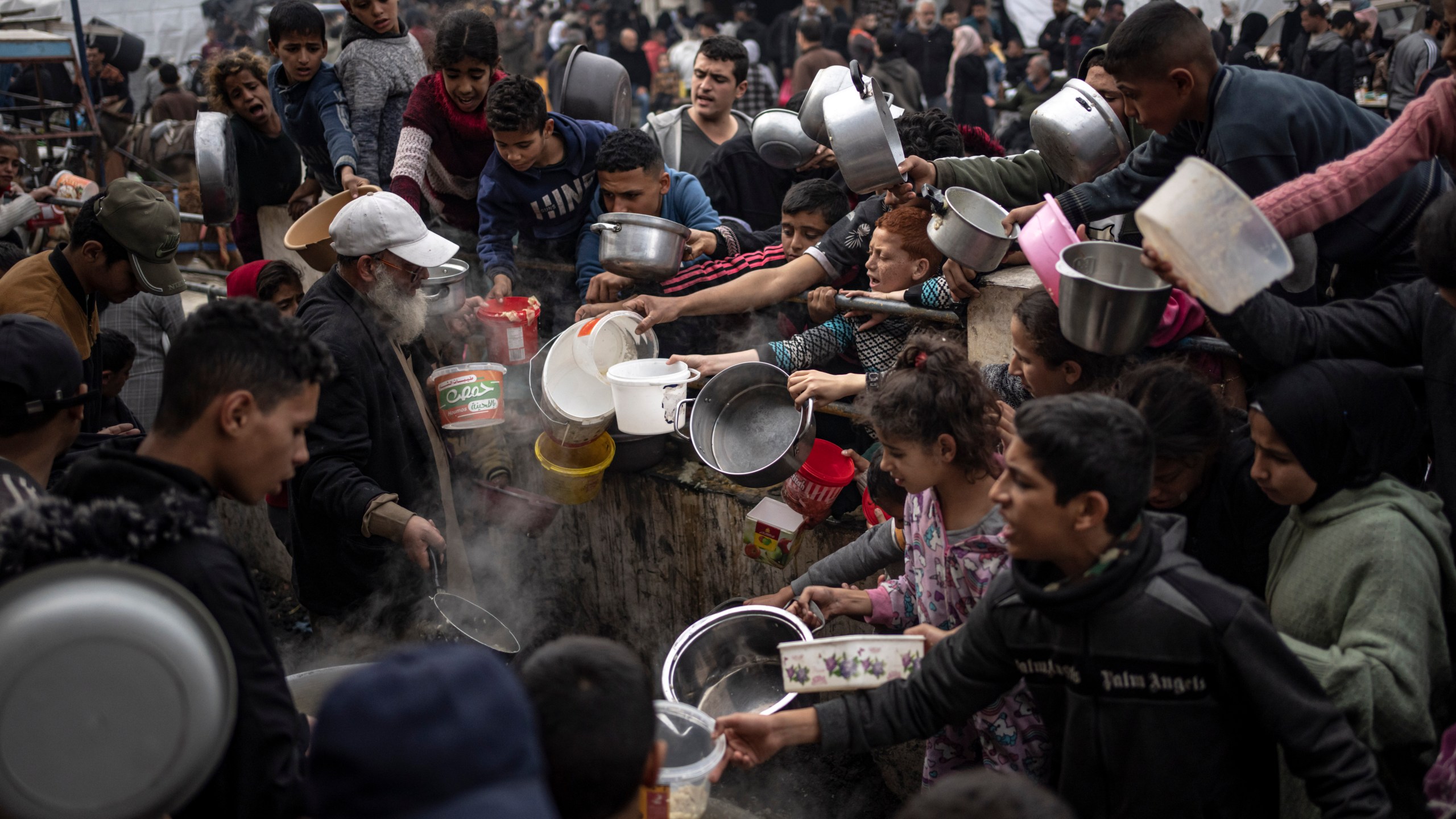 FILE - Palestinians line up for a meal in Rafah, Gaza Strip, Dec. 21, 2023. Israel and Hamas appear to be seriously negotiating an end to the war in Gaza and the return of Israeli hostages. A leaked truce proposal hints at concessions by both sides following months of stalemated talks. (AP Photo/Fatima Shbair, File)