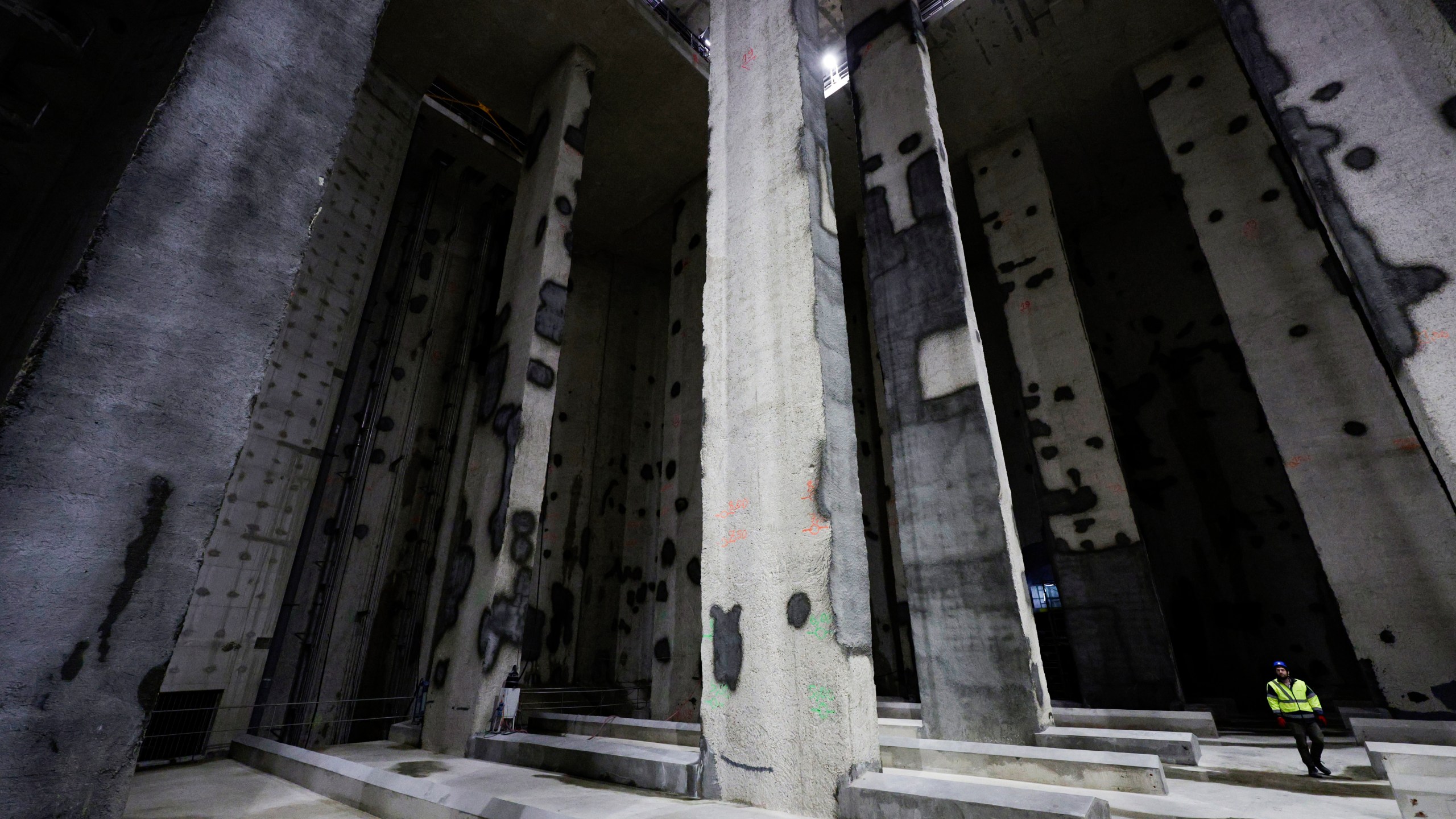 A man walks in the Austerlitz wastewater and rainwater storage basin, which is intended to make the Seine river swimmable during the Paris 2024 Olympic Games, in Paris, during its inauguration Thursday, May 2, 2024. The works underground next to Paris' Austerlitz train station are part of a 1.5 billion euro effort to clean up the Seine so it can host marathon swimming and triathlon events at the July 26-Aug 11 Summer Games and be opened to the general public for swimming from 2025. (Stephane de Sakutin, Pool via AP)