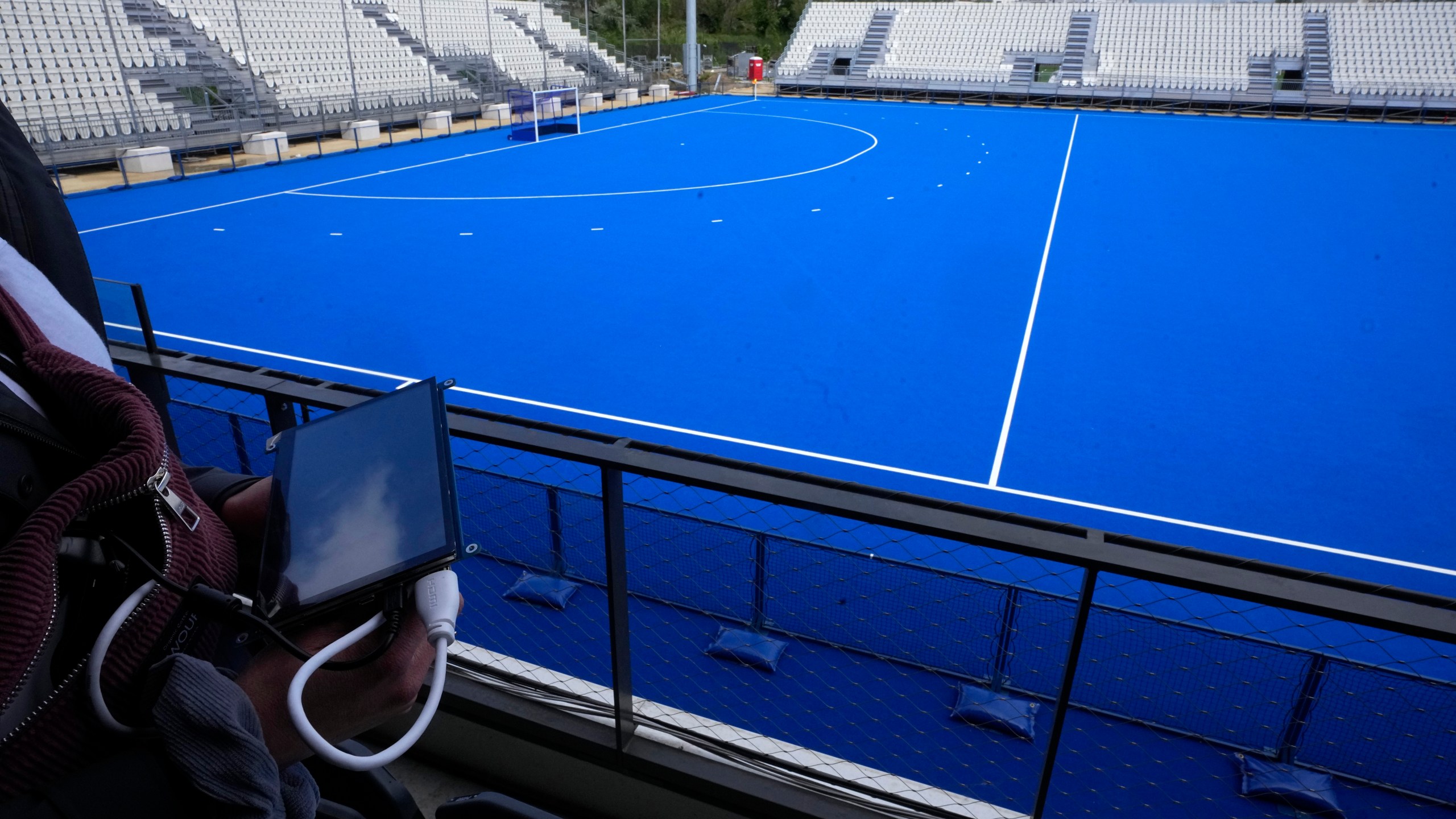 A cyber-security experts hold a tablet at the Yves du Manoir stadium, Friday, May 3, 2024 in Colombes, outside Paris. Cyber-security teams working to protect the Paris Games from hackers and other attackers aren't willing to divulge too much detail about their work. But they no doubt that cyber-criminals are going to keep them busy. (AP Photo/Michel Euler)