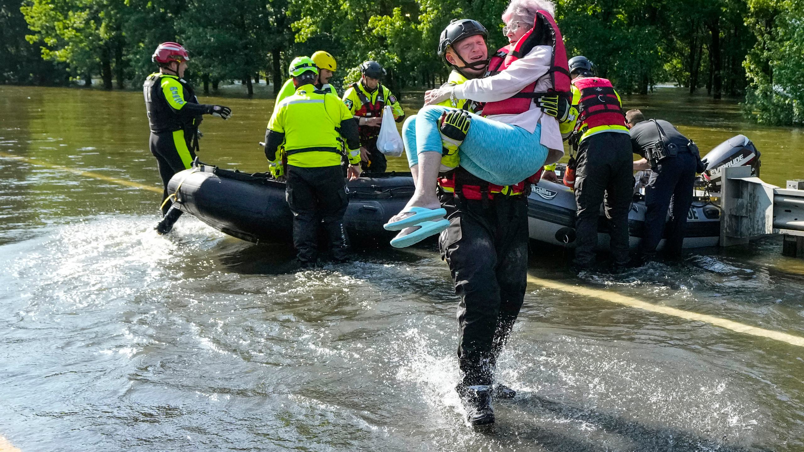 Conroe firefighter Cody Leroy carries a resident evacuated in a boat by the CFD Rapid Intervention Team from her flooded home in the aftermath of a severe storm, Thursday, May 2, 2024, in Conroe, Texas. (Brett Coomer/Houston Chronicle via AP)