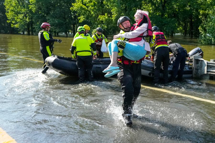 Conroe firefighter Cody Leroy carries a resident evacuated in a boat by the CFD Rapid Intervention Team from her flooded home in the aftermath of a severe storm, Thursday, May 2, 2024, in Conroe, Texas. (Brett Coomer/Houston Chronicle via AP)