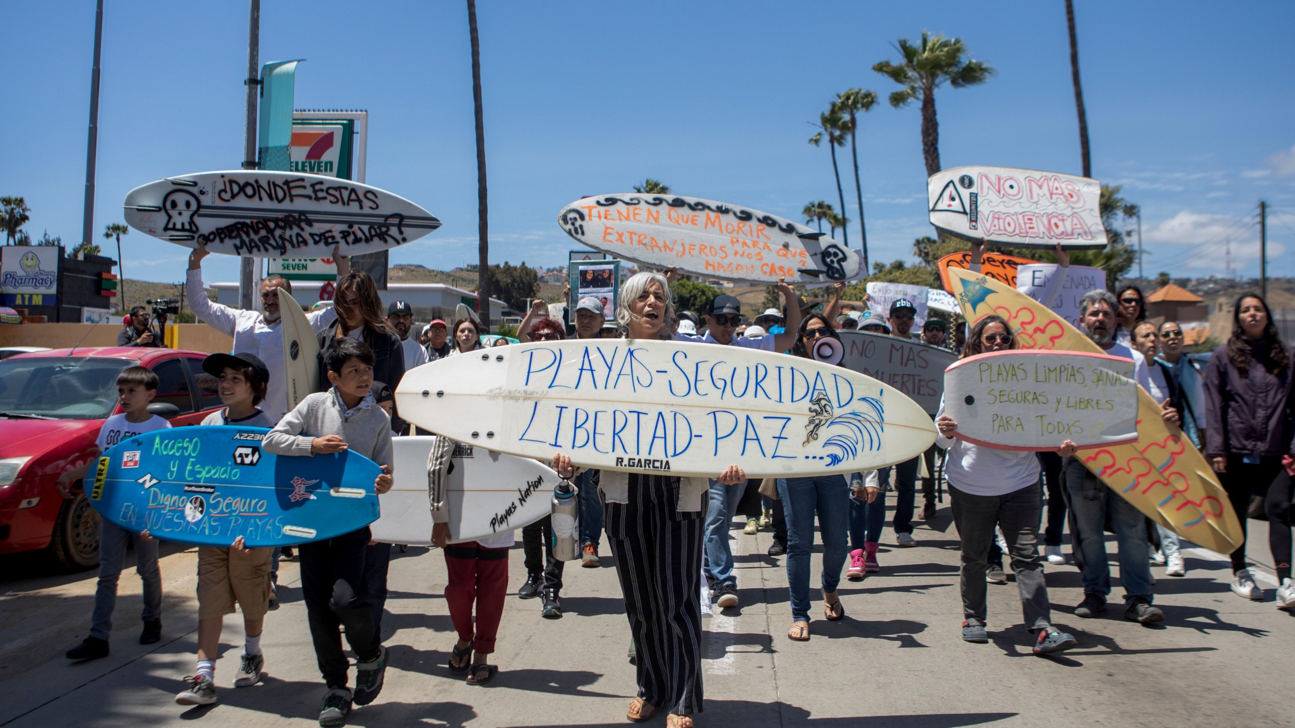 Locals march to protest the disappearance of foreign surfers in Ensenada, Mexico, Sunday, May 5, 2024. Mexican authorities said Friday that three bodies were recovered in an area of Baja California near where two Australians and an American went missing last weekend during an apparent camping and surfing trip. (AP Photo/Karen Castaneda)