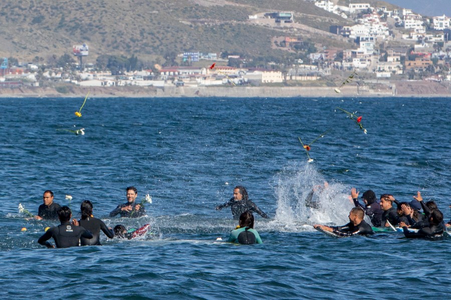 Surfers throw flowers during a tribute to 3 missing surfers in Ensenada, Mexico, Sunday, May 5, 2024. Mexican authorities said Friday that three bodies were recovered in an area of Baja California near where two Australians and an American went missing last weekend during an apparent camping and surfing trip. (AP Photo/Karen Castaneda)