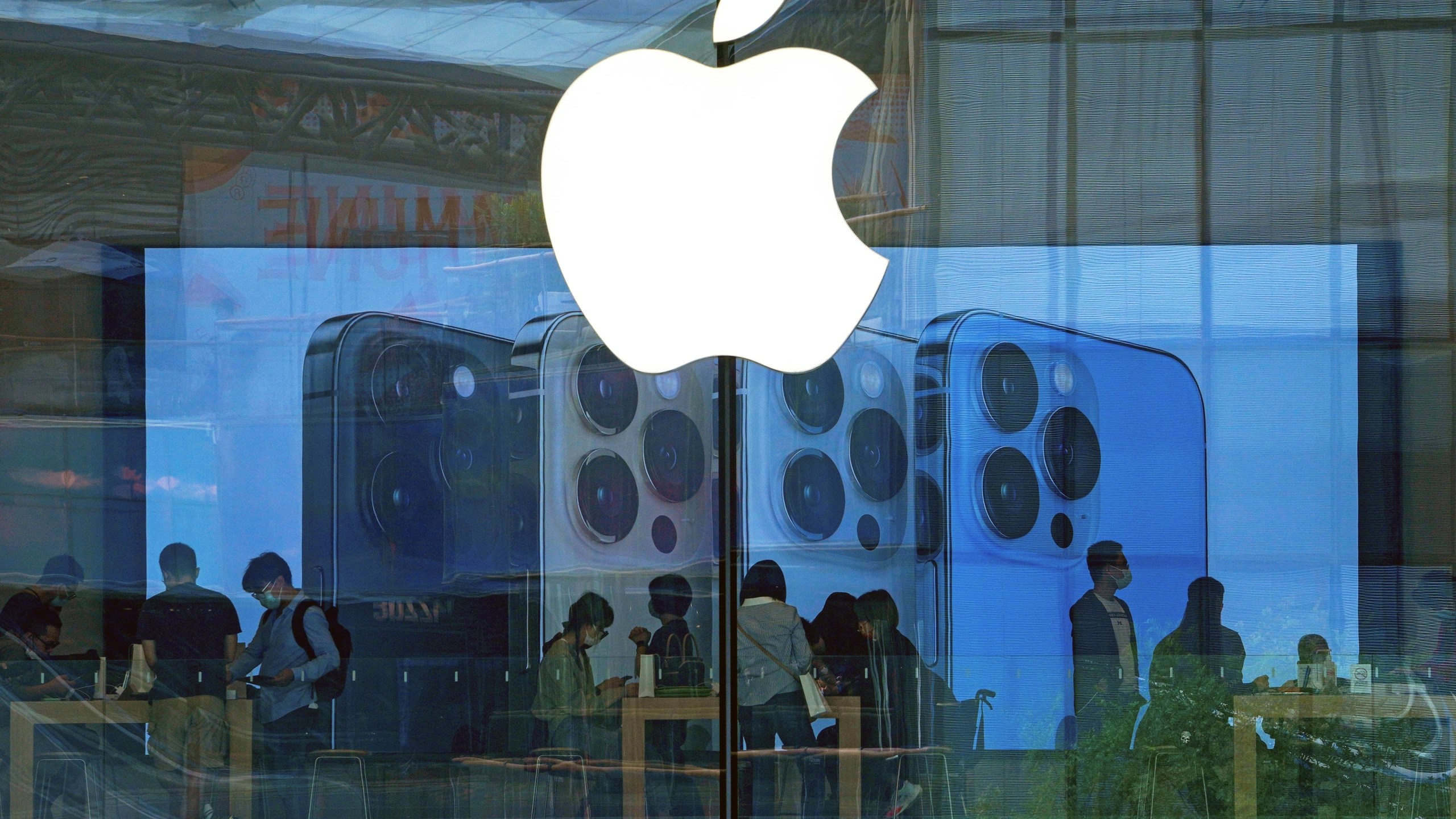 FILE - People try out iPhone products at an Apple Store in Beijing, Sept. 28, 2021. A federal judge on Wednesday questioned whether Apple has set up a gauntlet of exasperating hurdles to discourage the use of alternative payment options in iPhone apps, despite a court order seeking to create more ways for consumers to pay for digital services. (AP Photo/Andy Wong, file)