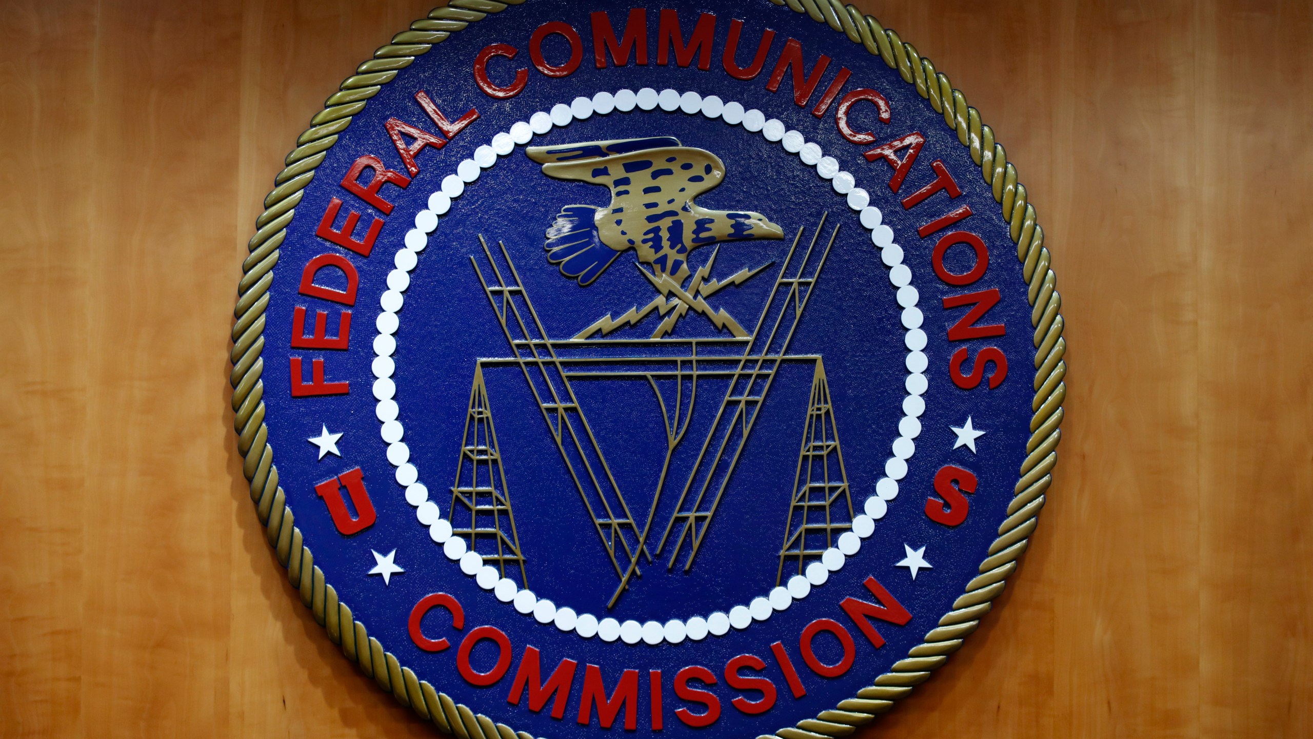 FILE - The seal of the Federal Communications Commission (FCC) is seen before an FCC meeting to vote on net neutrality, Dec. 14, 2017, in Washington. The FCC on Thursday, April 25, 2024 restored “net neutrality” rules that prevent broadband internet providers such as Comcast and AT&T from favoring some sites and apps over others.. (AP Photo/Jacquelyn Martin, File)