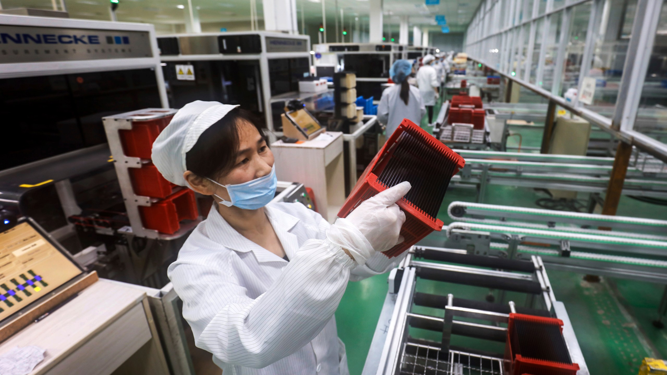 FILE - A worker checks solar panels at a factory in Jiujiang in central China's Jiangxi province on March 16, 2018. The Biden administration is planning to announce new tariffs on electric vehicles, semiconductors, solar equipment and medical supplies imported from China. (Chinatopix via AP)