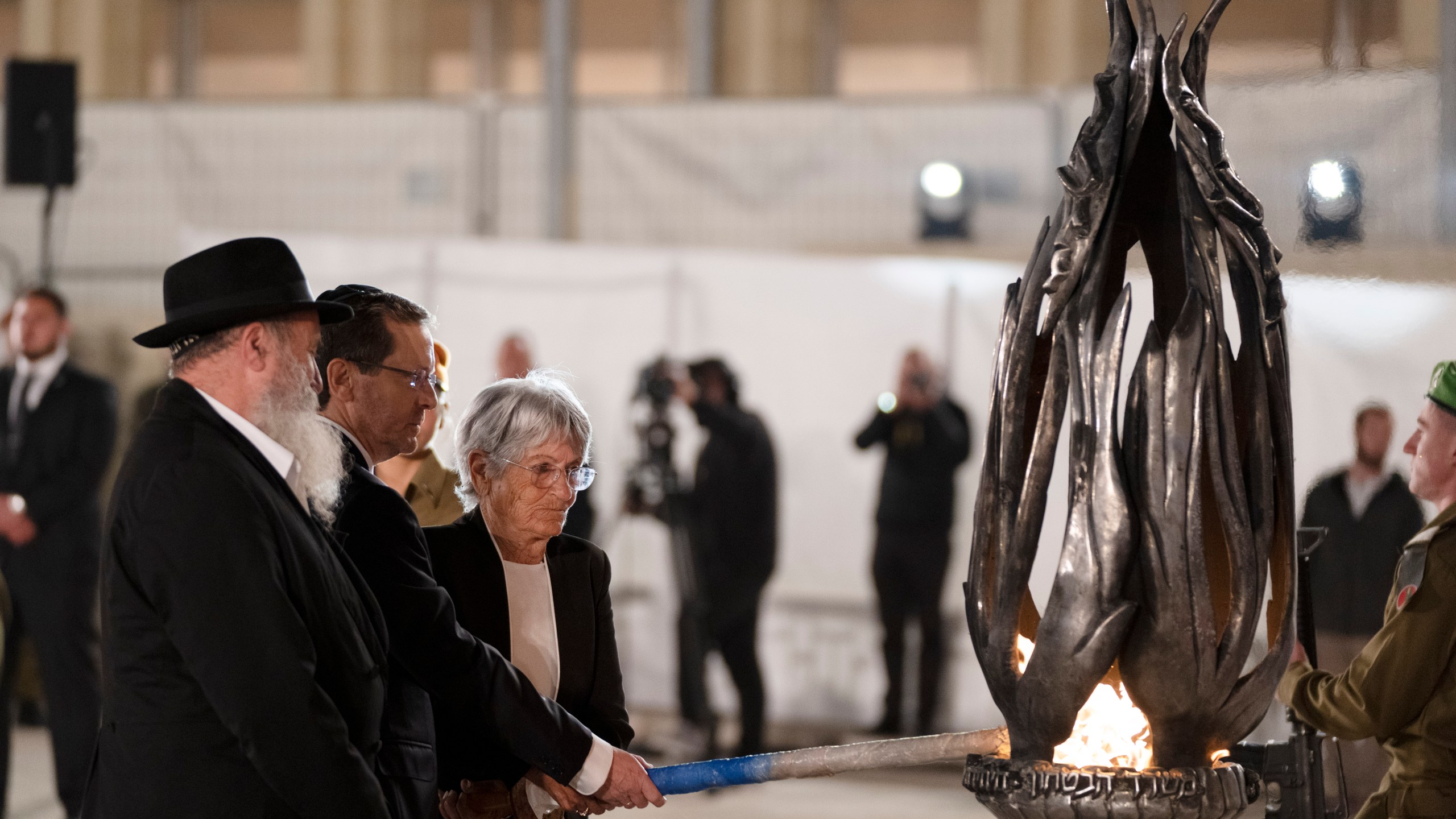 Israeli president Isaac Herzog, second from left, lights the fire during the ceremony marking Israel's annual Memorial Day for fallen soldiers and victims of nationalistic attacks at the Western Wall, the holiest site where Jews can pray, in the Old City of Jerusalem, Sunday, May 12, 2024. (AP Photo/Leo Correa)