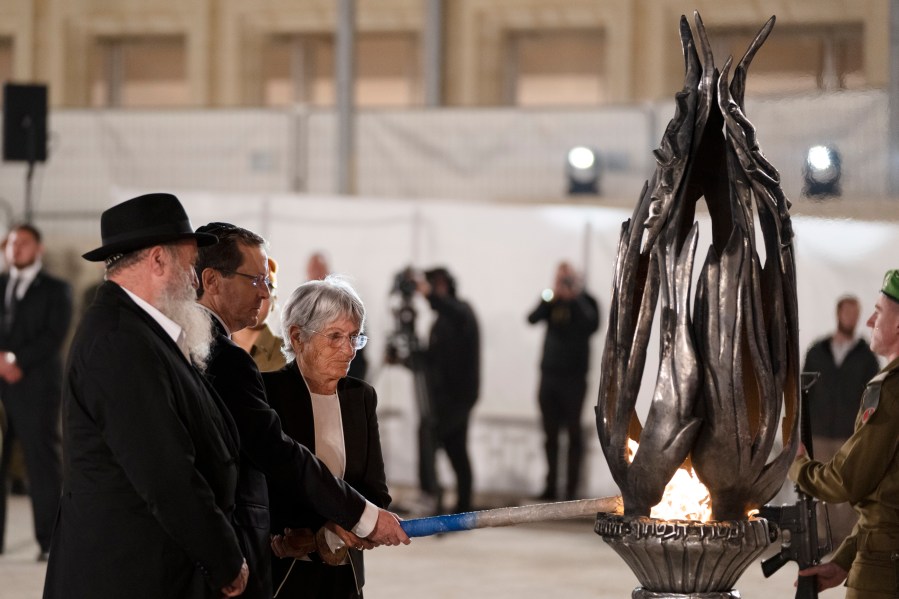 Israeli president Isaac Herzog, second from left, lights the fire during the ceremony marking Israel's annual Memorial Day for fallen soldiers and victims of nationalistic attacks at the Western Wall, the holiest site where Jews can pray, in the Old City of Jerusalem, Sunday, May 12, 2024. (AP Photo/Leo Correa)