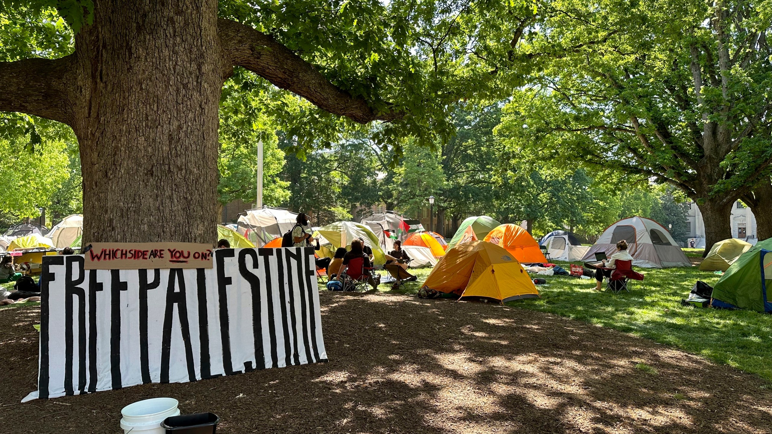 FILE - Students and other community members sit outside tents in University of North Carolina at Chapel Hill's central grounds, Polk Place, as part of an encampment protest, April 29, 2024. On Monday, May 13, the University of North Carolina at Chapel Hill Board of Trustees approved a change that would divert $2.3 million of diversity funding to go toward public safety and policing. The vote to shift more funding to public safety comes as continued pro-Palestinian protests on UNC's campus have resulted in several arrests in recent weeks. (AP Photo/Makiya Seminera, File)